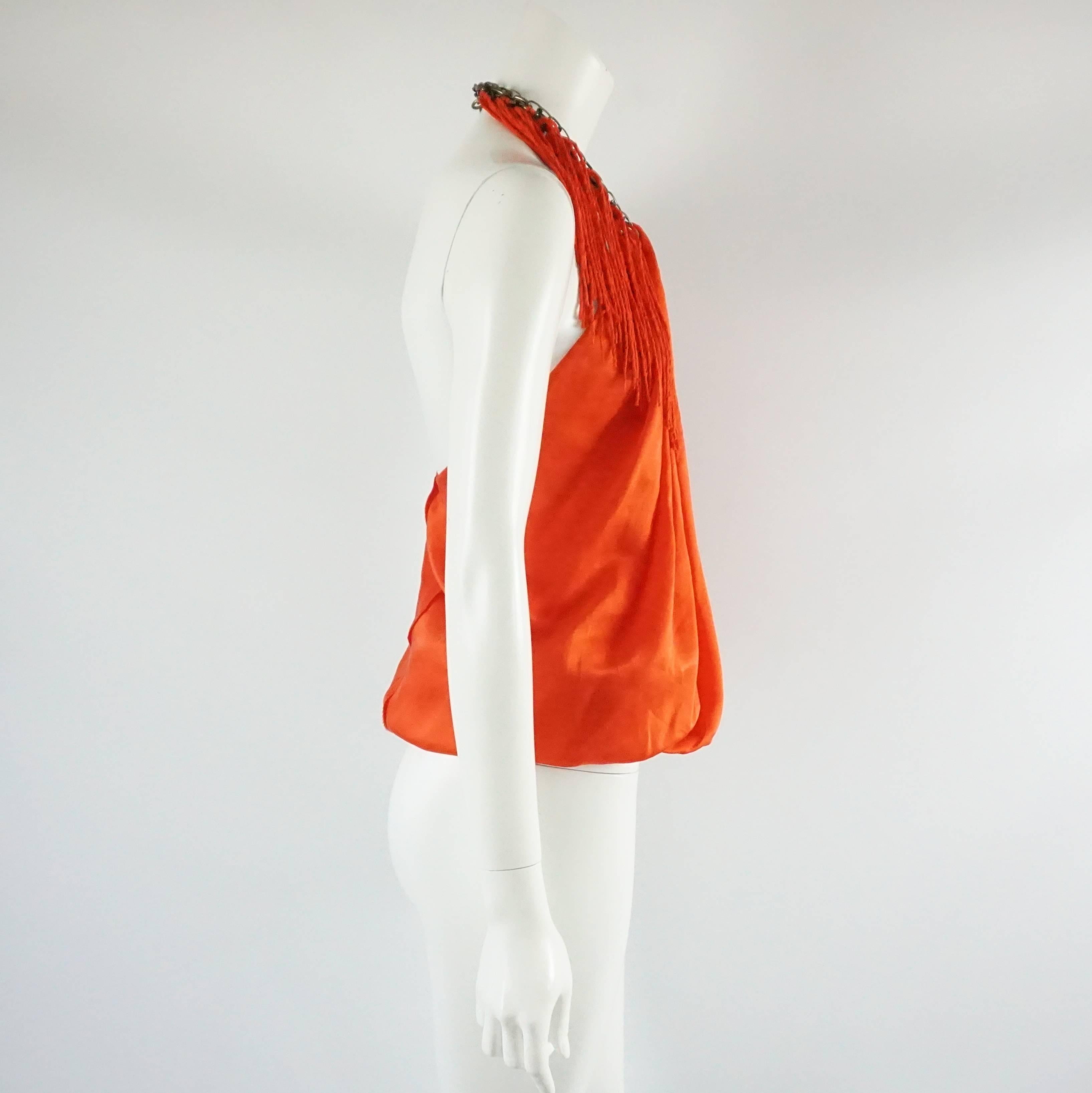 This Lanvin bright orange silk halter top has a chain by the neckline with hanging fringe tassels. The top is in good condition with a couple minor markings as shown in the last images. Size 38. 

Measurements
Bust: 35"
Waist: