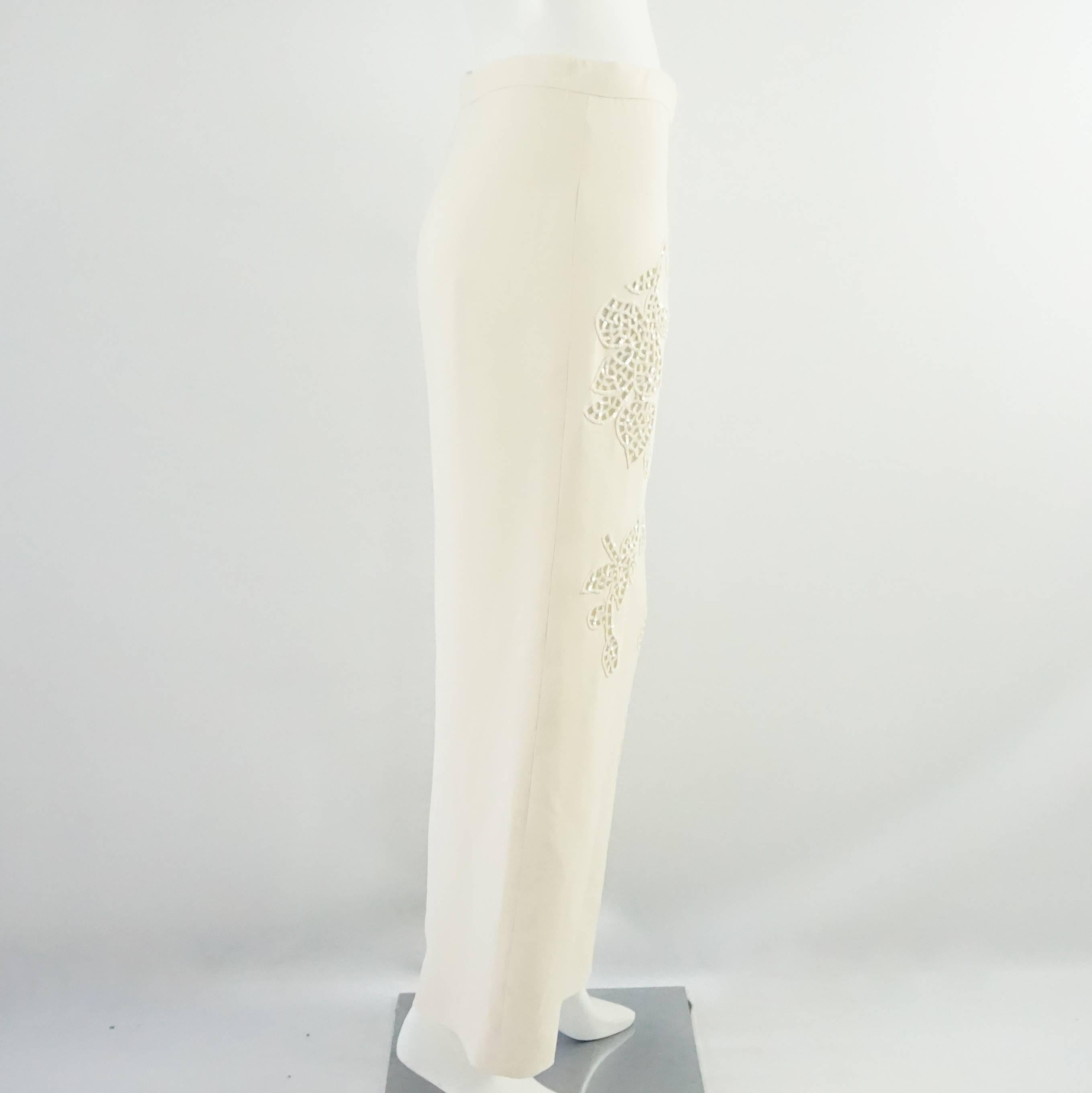 These Giorgio Armani ivory palazzo pants are made of silk and have cutouts with embroidery and sequins attached. The pants are in very good condition with a couple small pulls and minor stains. Size 6. 

Measurements
Waist: 30.5"
Hips: