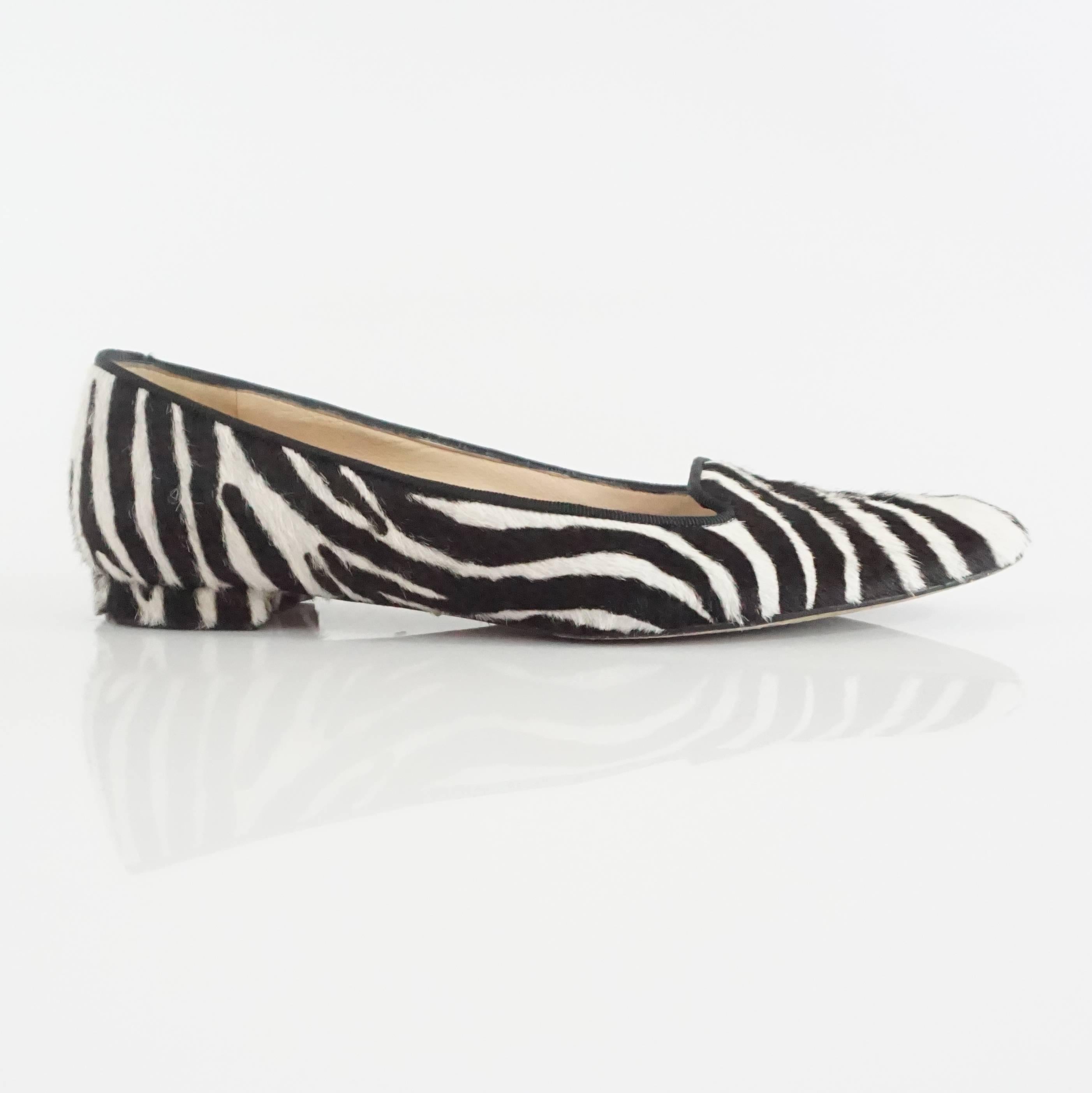 These Manolo Blahnik flats are black and white and are made of pony hair. They have a slightly pointed toe and a thin black trim. The flats are in excellent condition with some bottom wear. 
