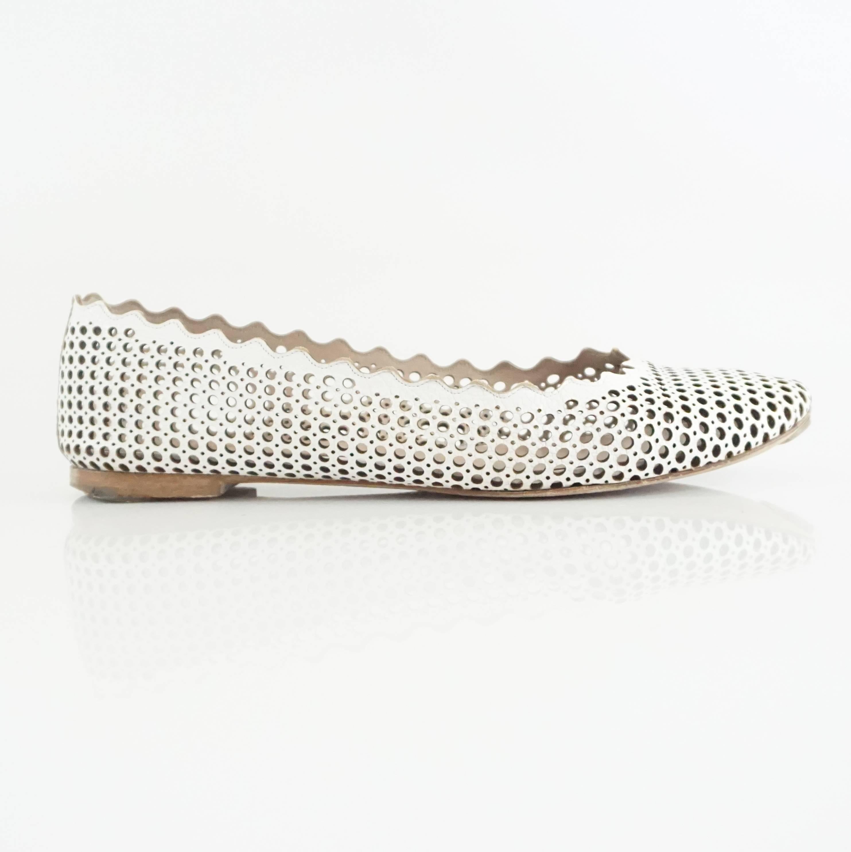 These Chloe white perforated leather flats have a unique look. They have a scalloped trim with different size perforations all along the leather. The flats are in very good condition with some bottom wear as seen in the images. Purchase comes with