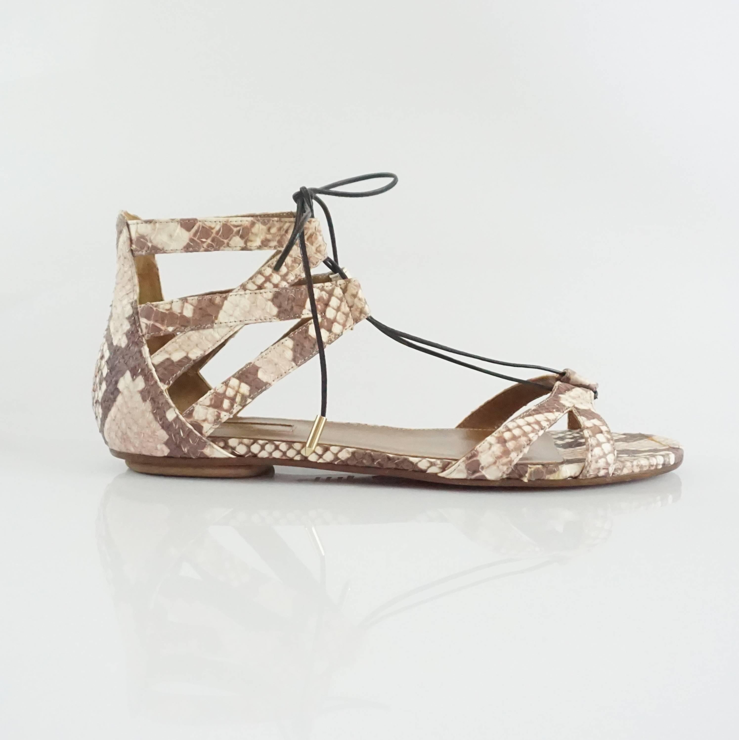 These Aquazzura lace-up sandals are made of snake. They sandals are a mix of ivory, taupe, and earthtones and lace up at the ankles. The shoes are in excellent condition with minimal bottom wear. 