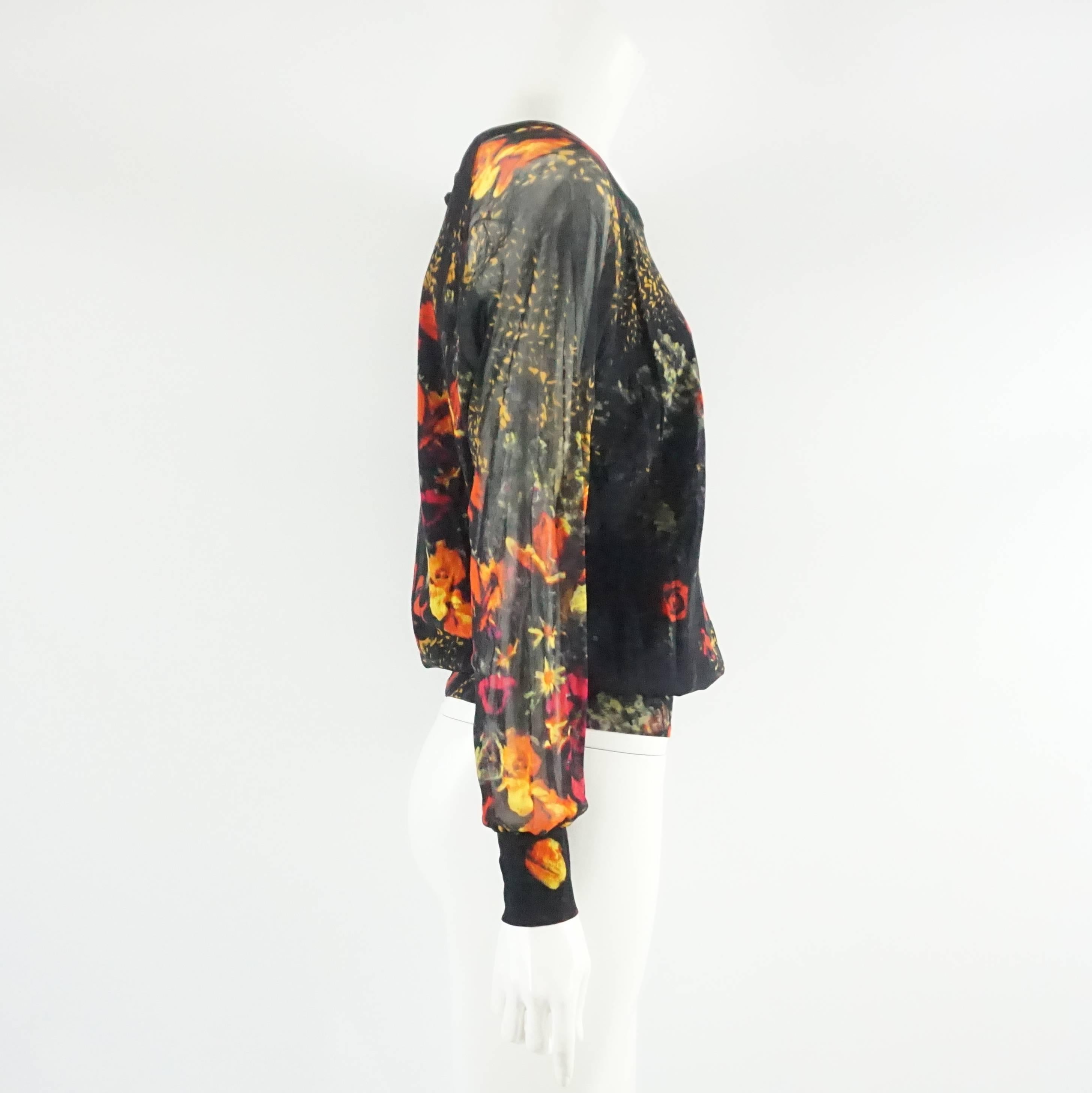 This Jean Paul Gaultier 90's top is black with a multi color floral print. The piece is long sleeved and is made of mesh with a interior black lining. It is in excellent vintage condition with minimal wear. Size S, circa 2000’s.