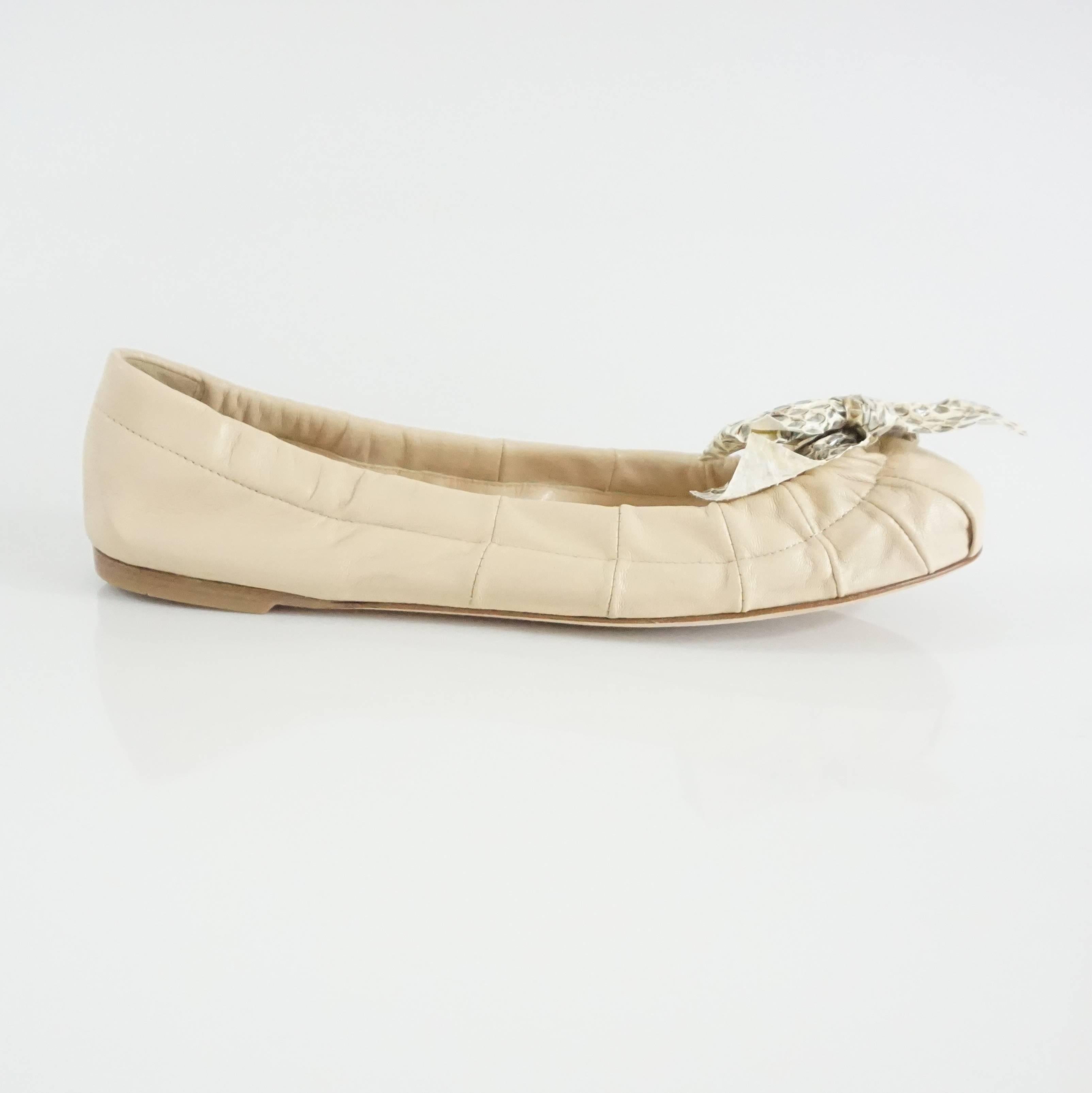 These Prada flats are cream leather. The feature snake skin bows. These flats are in excellent condition with minor wear on one of the bows. Size 38. 
