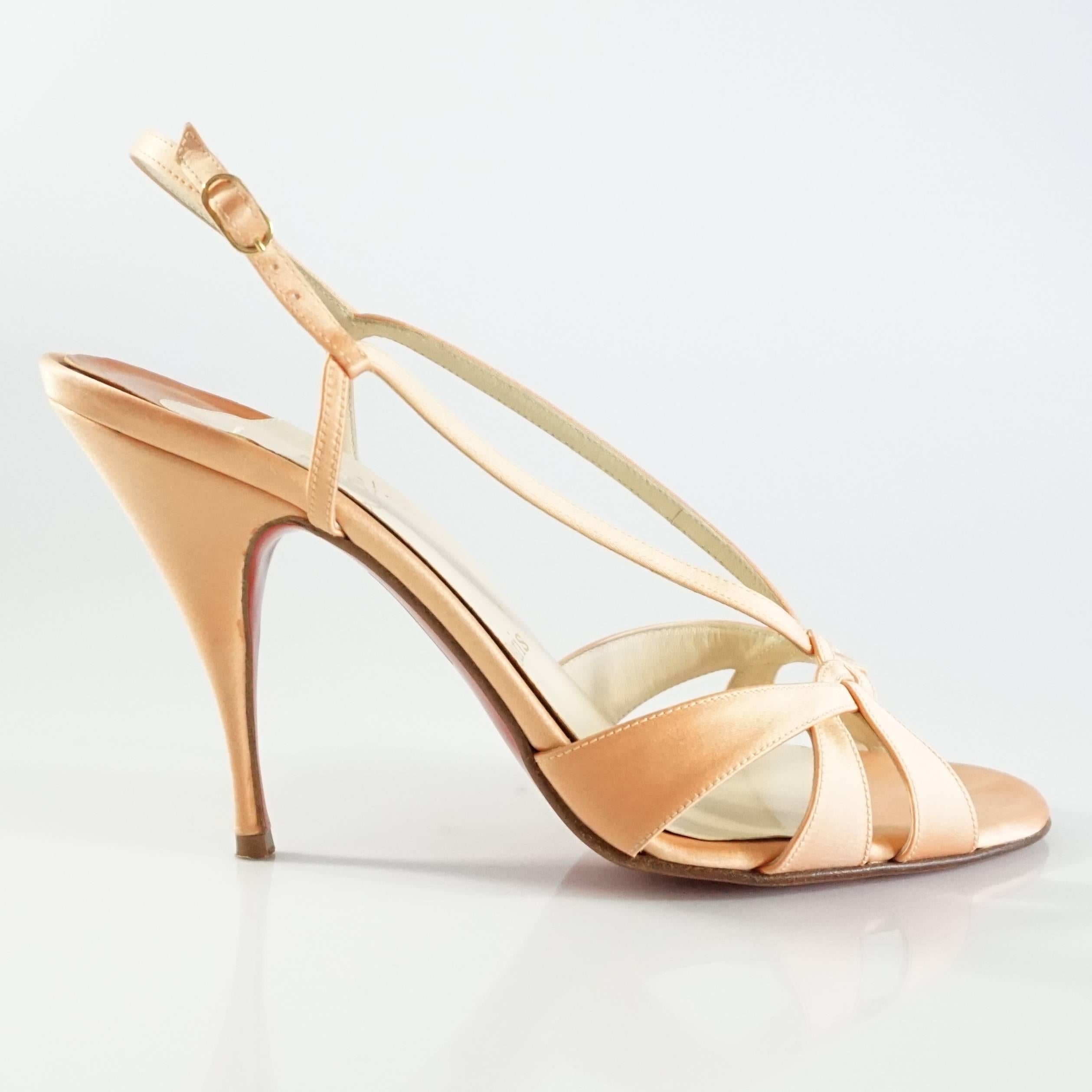These Christian Louboutin heels are orange satin. They have a strappy design. These heels are in good condition with minor wear on the bottom, some markings on the fabric, wear on the toe bed, and lifted soles. Size 39.5.

Heel Height: 4”
