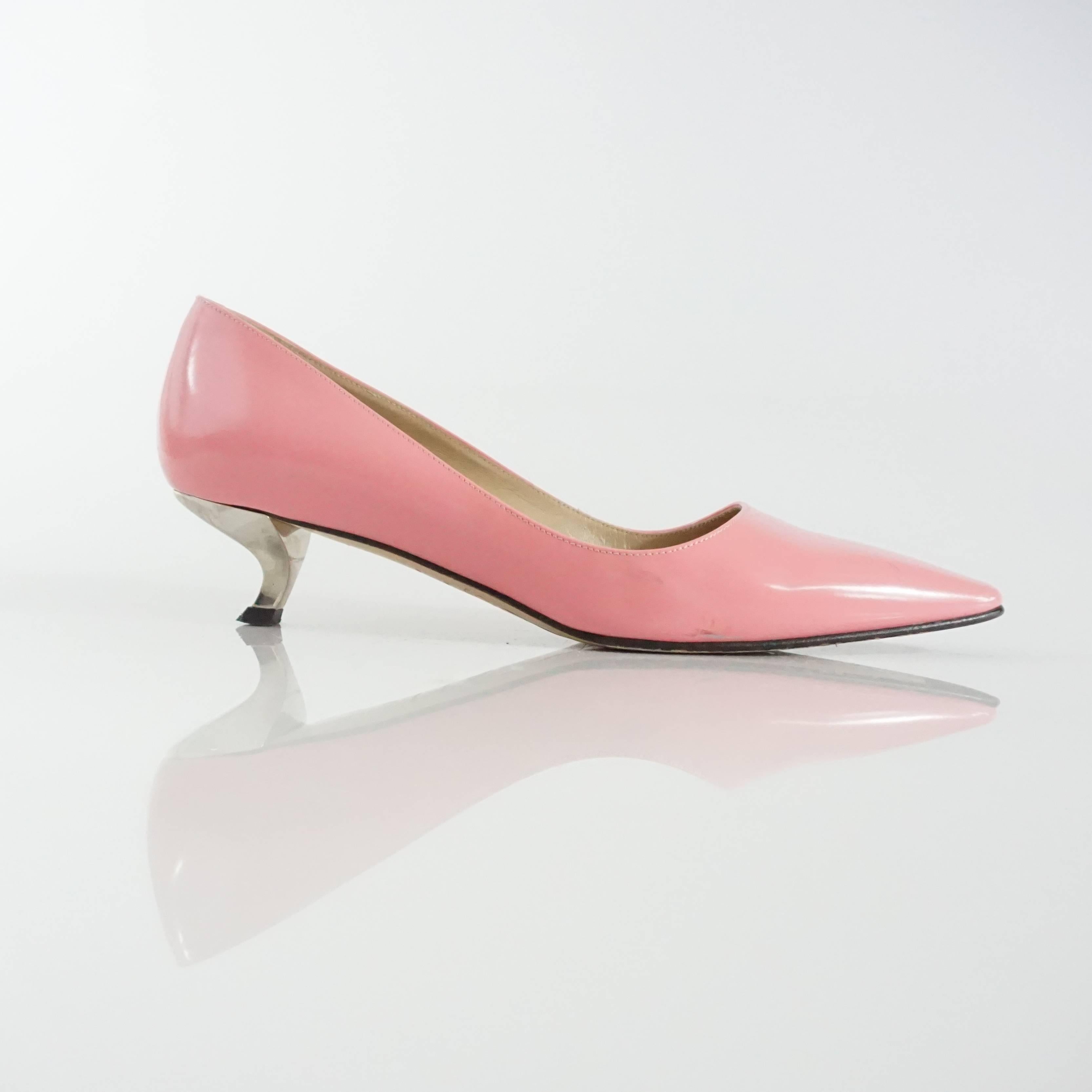These Roger Vivier pink leather flats have a small silver heel. They feature a tapered toe. These shoes are in fair condition with many marks.

Heel Height: 1.63"