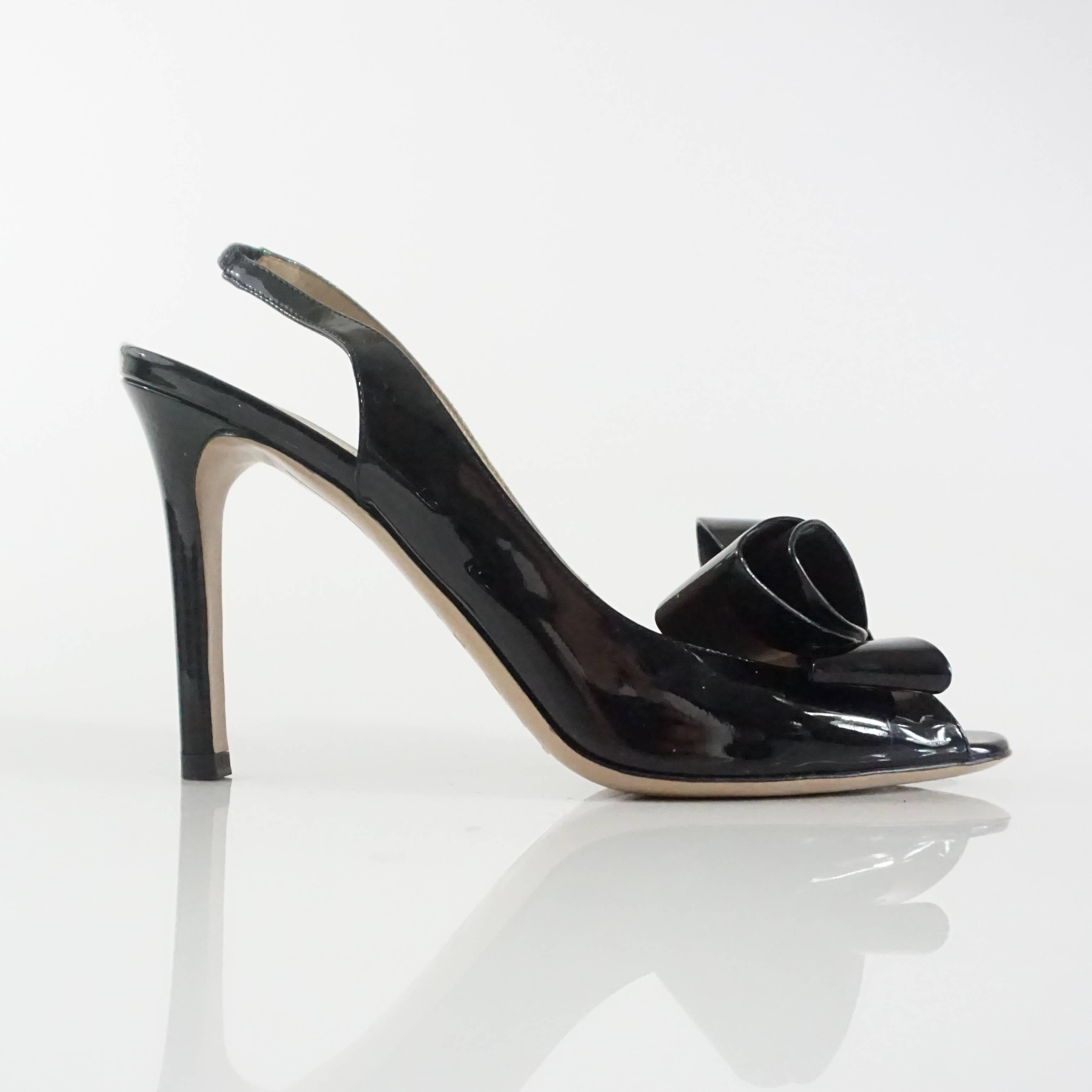 These Valentino heels are black patent leather. They feature a peeptoe, slingback design, and bow detailing. These feels are in excellent condition with some wear on the bottom.Size 36.5.

Measurements
Heel: 3.75"
Platform: about 0.38"