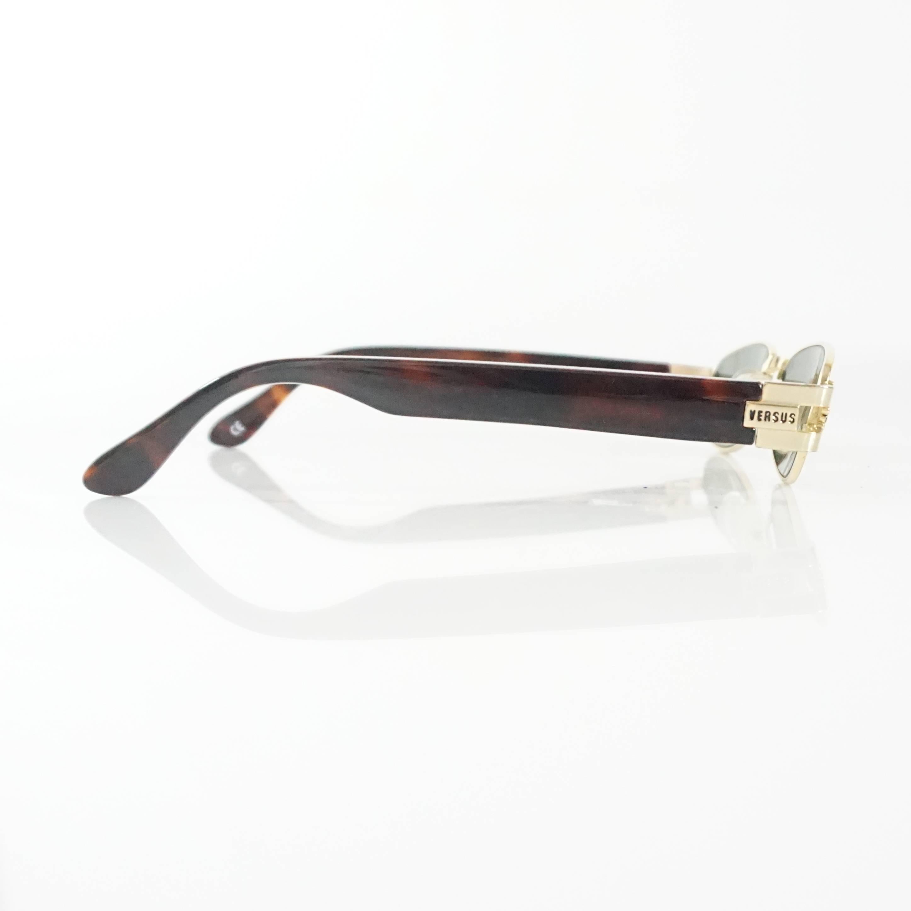 These Versus Versace sunglasses feature small rectangular lenses. The legs are thick and brown and gold tortoiseshell print. These sunglasses are in excellent condition. 

Measurements
Front Length: 5.13"
Leg Length: 5.75"
Length of Lens: