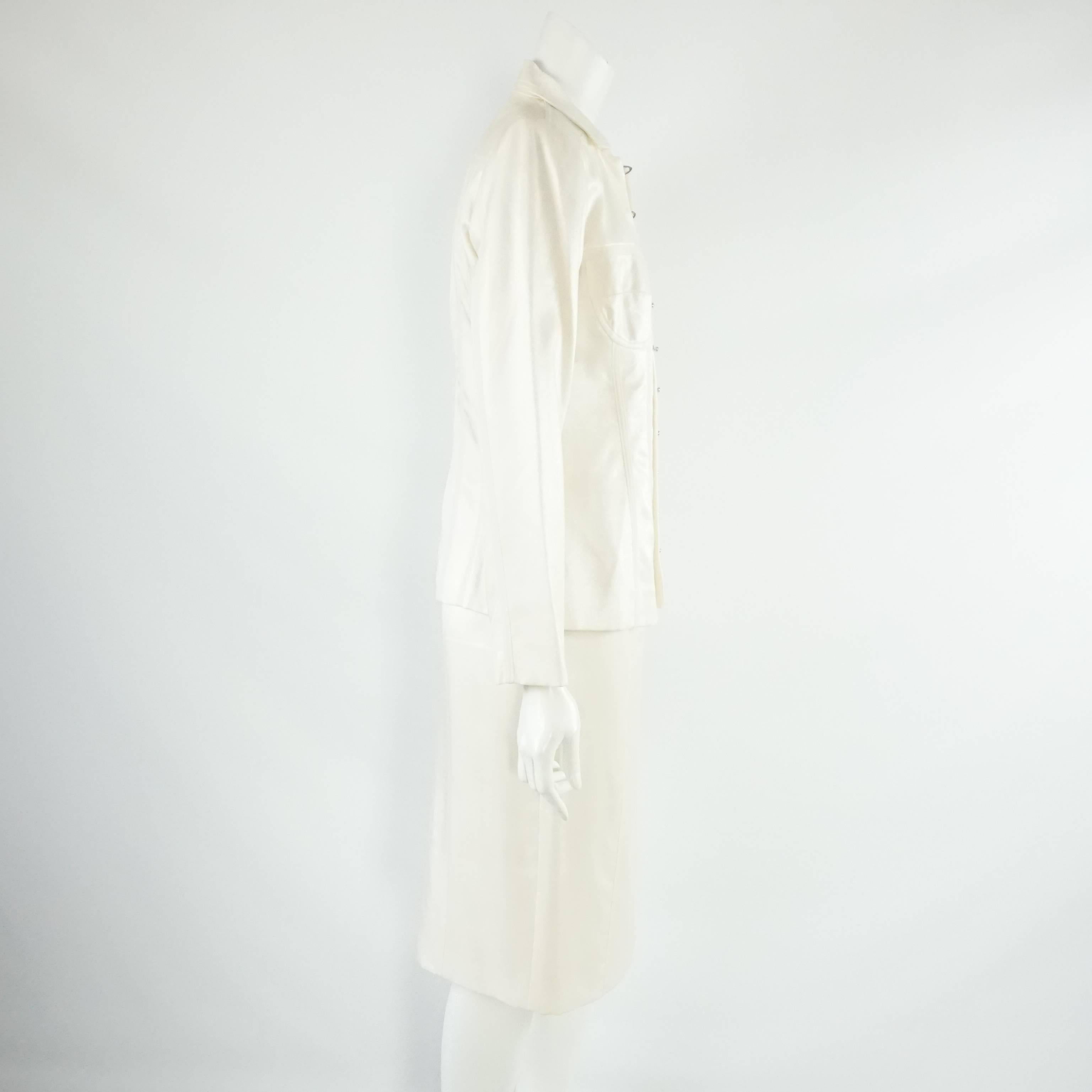 Christian Dior Ivory Wool Blend Dress and Jacket - 38 & 40. This Dior ivory set features a sleeveless wool blend dress with a v-neckline and a side slit. There is a matching jacket with silver closures. This set is in very good condition with minor
