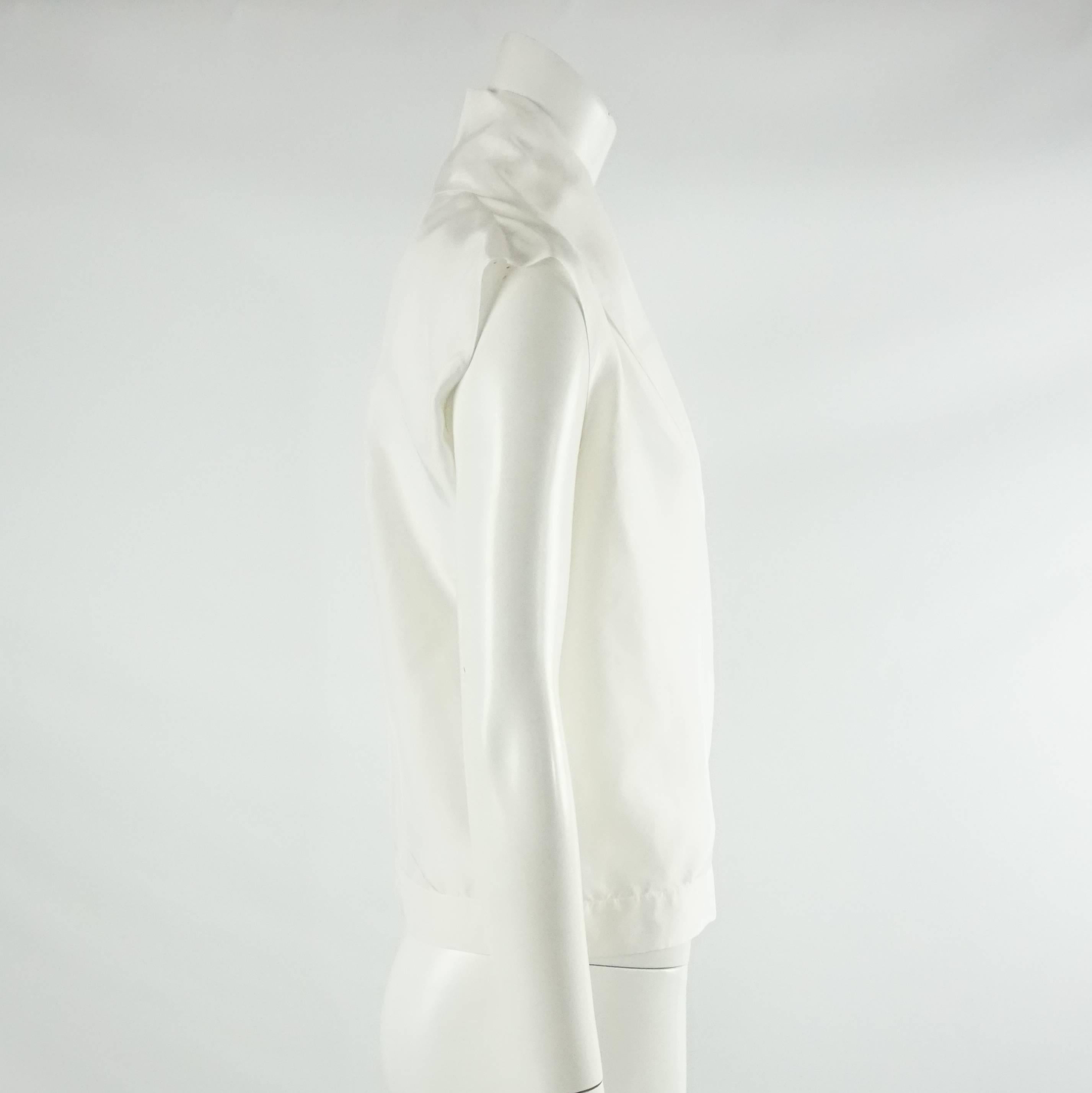 This classic YSL white cotton top is a very versatile piece. It is sleeveless with an overall loose fit and crossing front. The blouse is in excellent condition with no visible wear. Size, circa 2012. Size 36

Measurements
Shoulder to Shoulder: