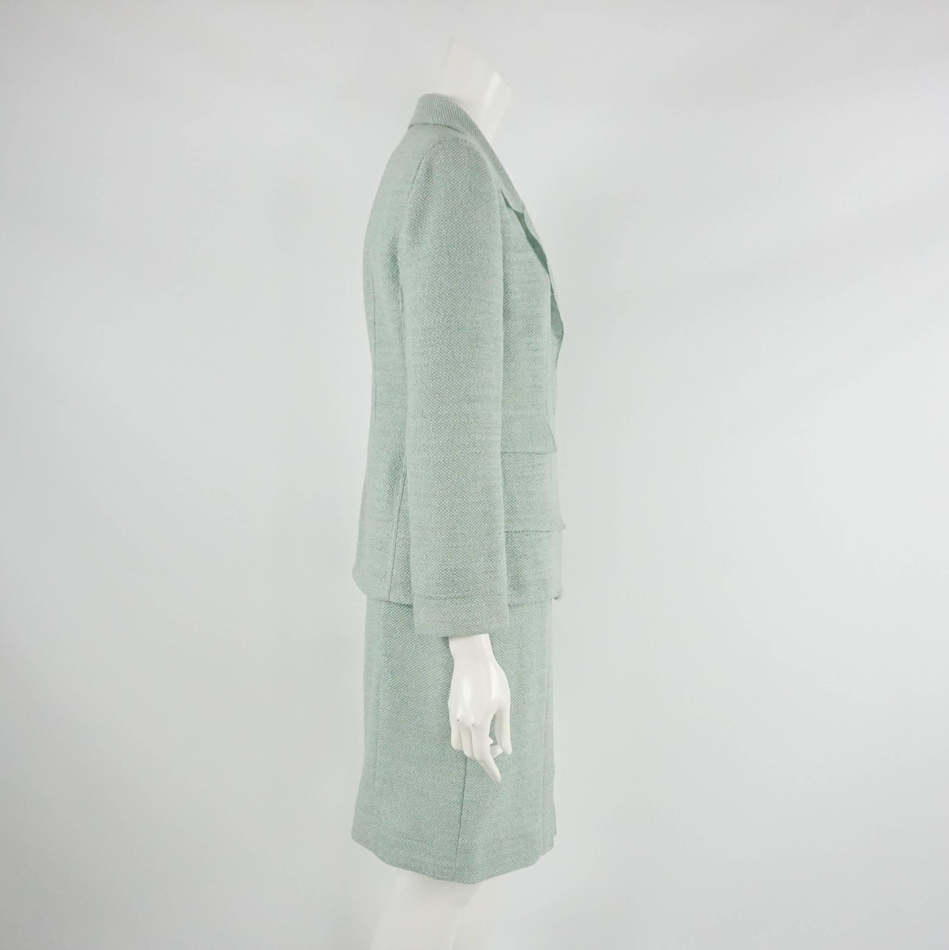 This classic Chanel pale blue skirt suit it made of a thin cotton-linen material. The jacket is single breasted with 4 pockets and has lucite "CC" buttons. The skirt zips in the back has pleating in the front. The set is in good condition