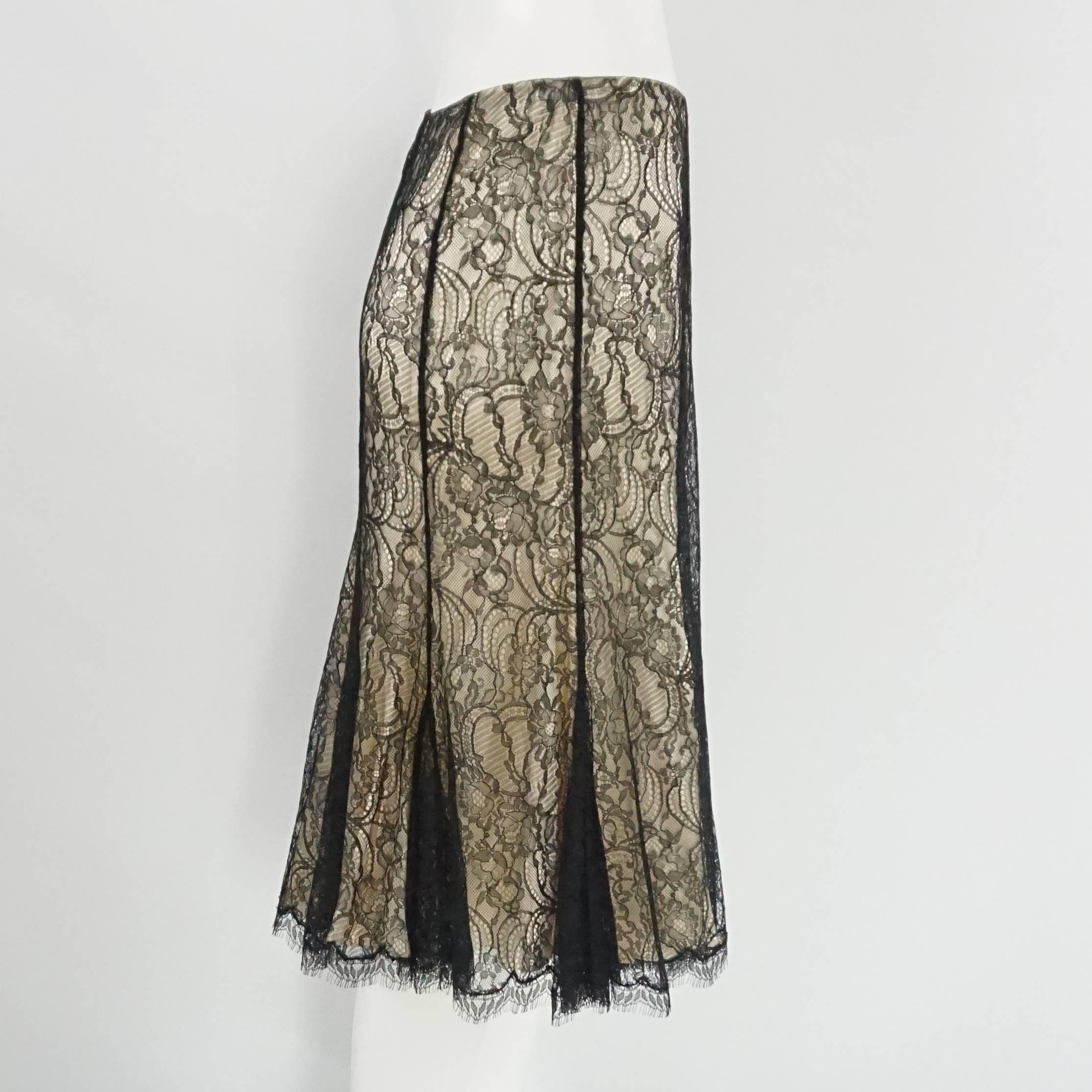 This Ralph Lauren black label skirt has a nude satin shell with a black lace overlay. The skirt zips in the back and also has small pleats on the bottom. The piece is in excellent condition with no visible wear.  Size 10, circa 21st century.