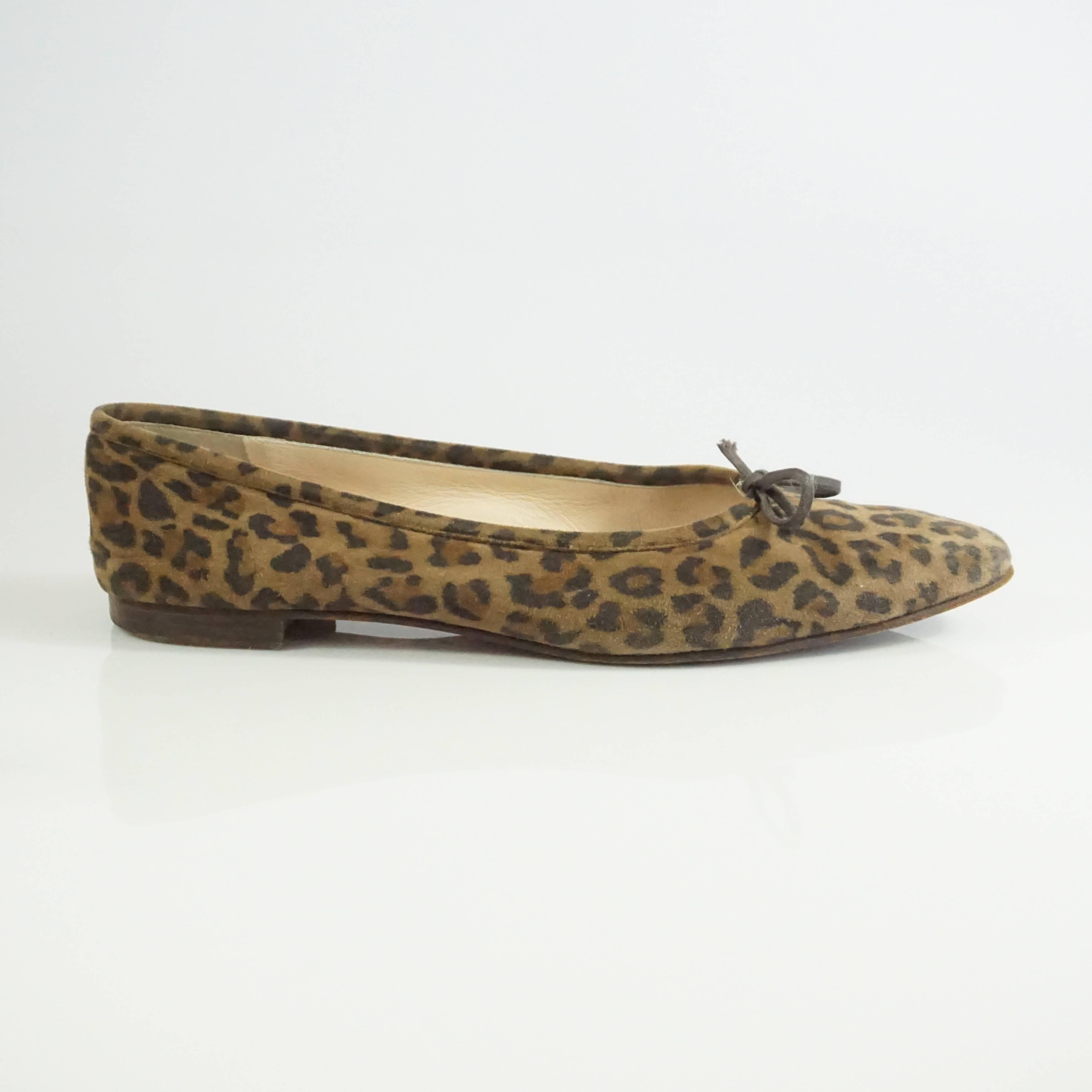 These Manolo Blahnik flats are made of suede and have a animal print all over. The flats also have a slight pointed toe and a small bow in the front. They are in fair condition with some wear to the bottom, heels, interior, and sides (all seen in