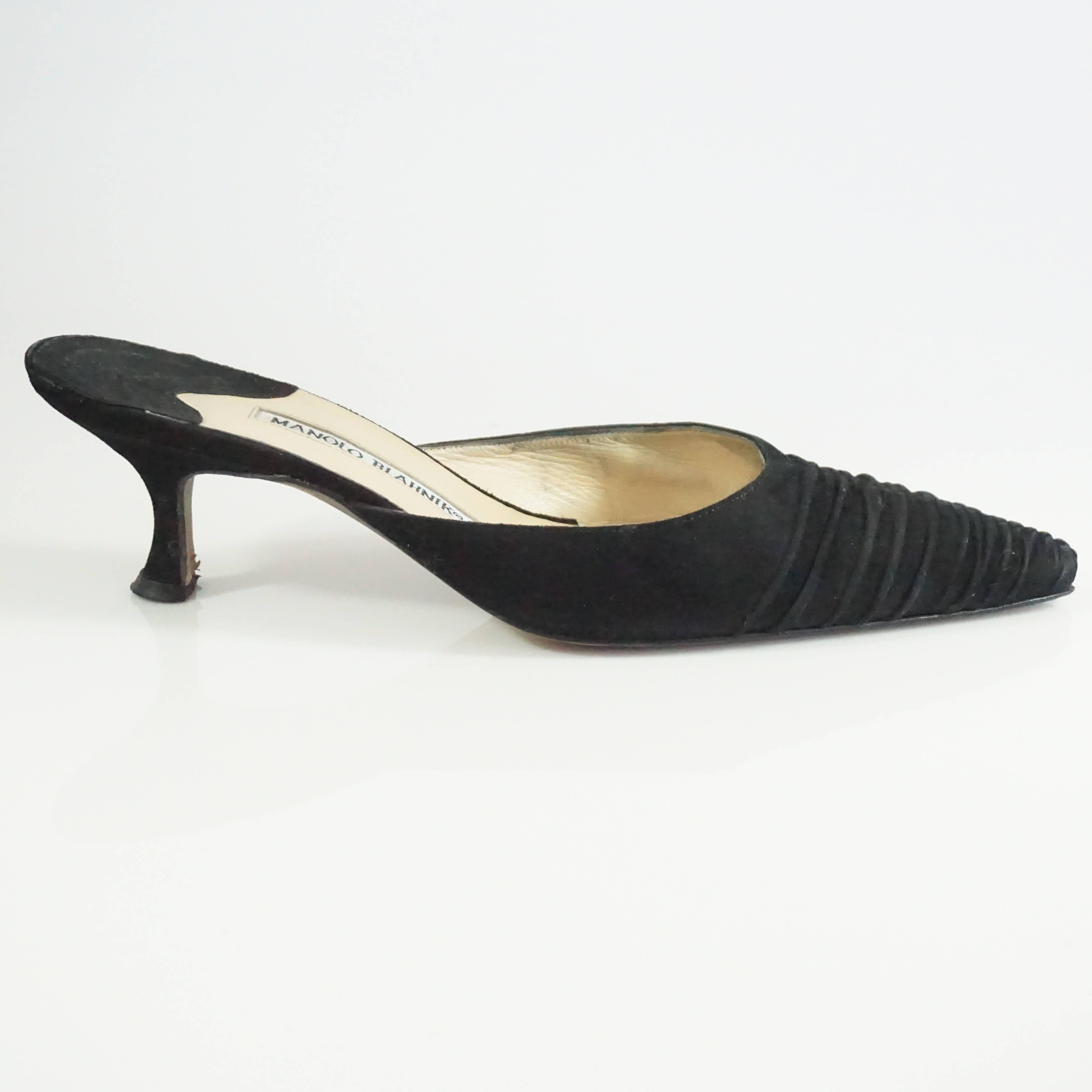 This Manolo Blahnik heel is a slide mule made of ruched black suede. The shoes are in fair condition with some wear on the bottom and some interior markings. Size 38.5.

Heel Height: 2"