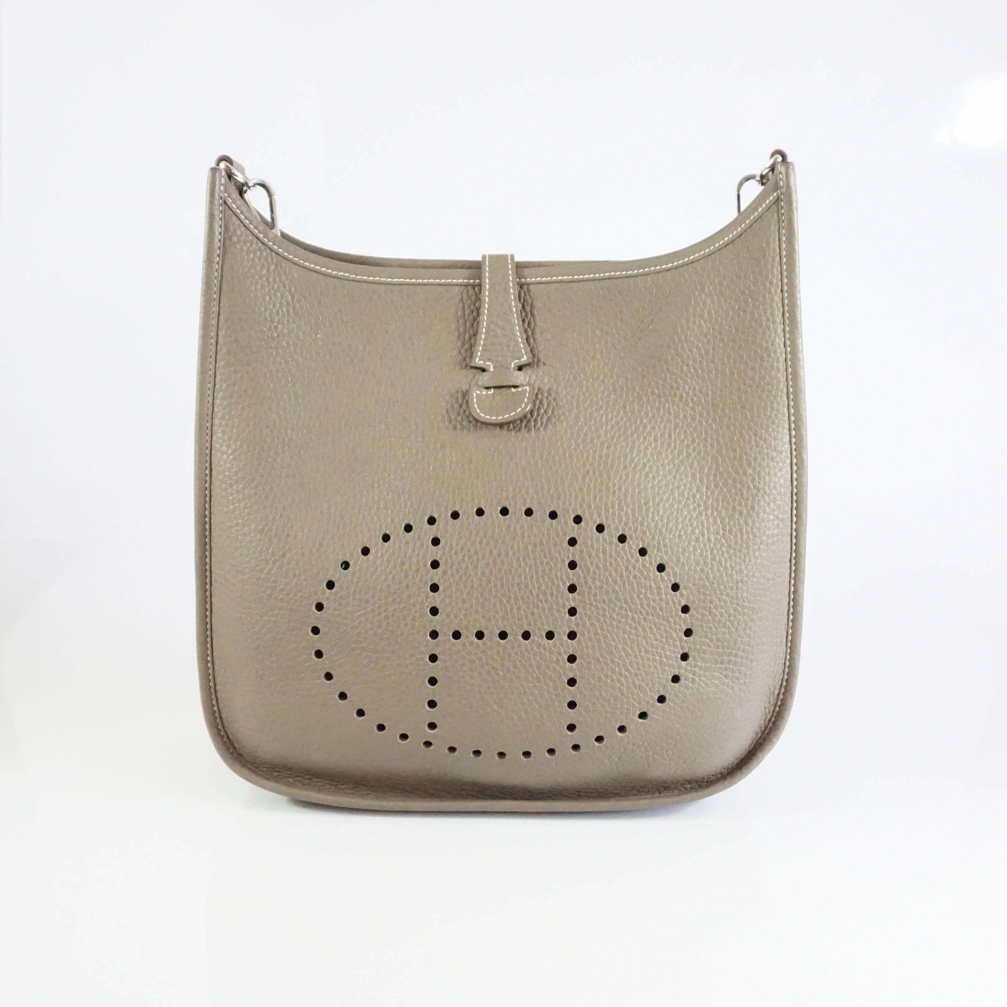 This staple Hermes Evelyne III PM is in the ultra wearable Etoupe color and the desirable Togo leather. The bag comes with a back pocket, a taupe crossbody strap, strap duster, book, bag duster, and box and sales receipt. The bag is in Pristine
