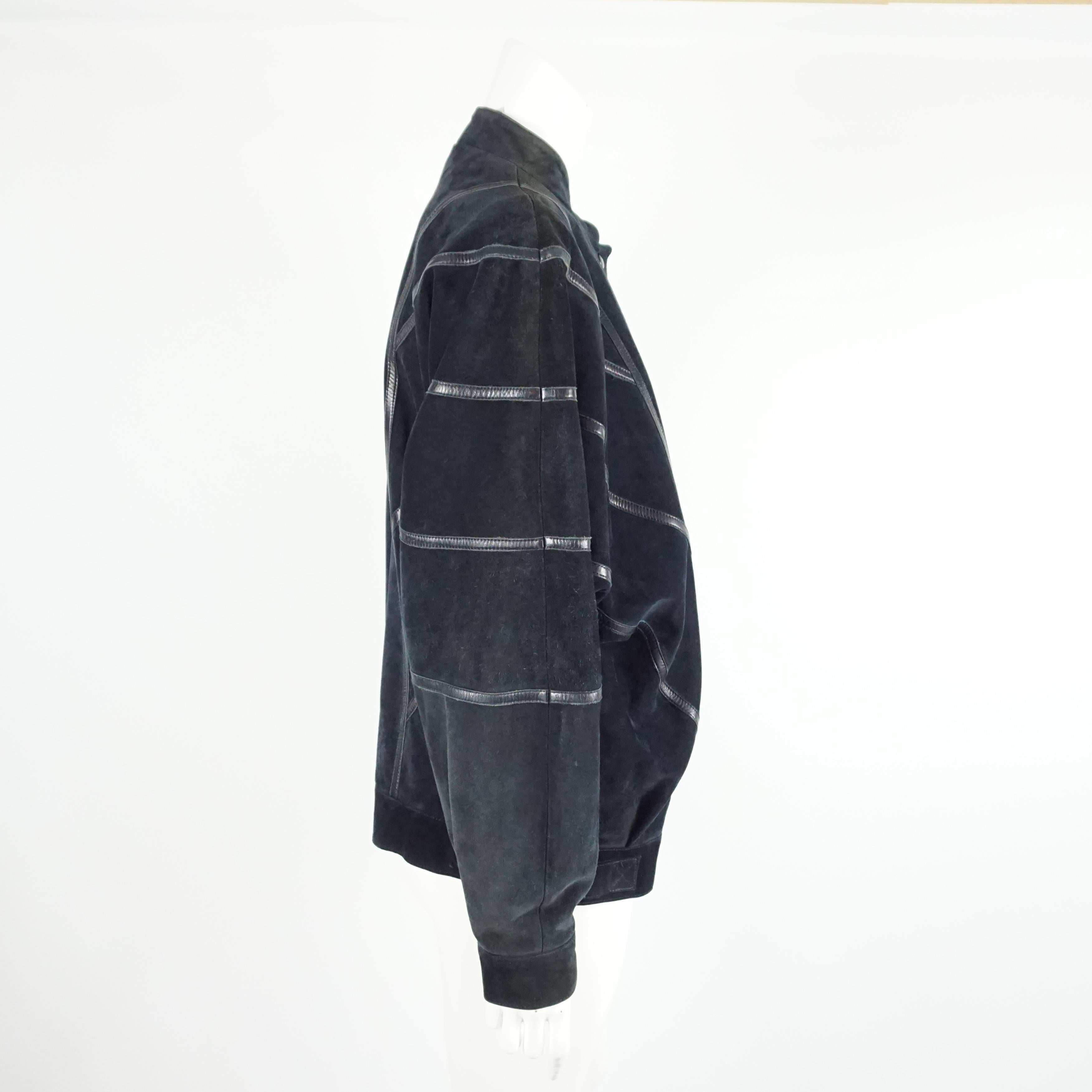This Celine navy suede jacket has an oversize fit and has leather stripe detailing all over. The jacket also features snap buttons. It is in fair vintage condition with discolorations and marks to the suede as seen in the last images. Size 42, circa
