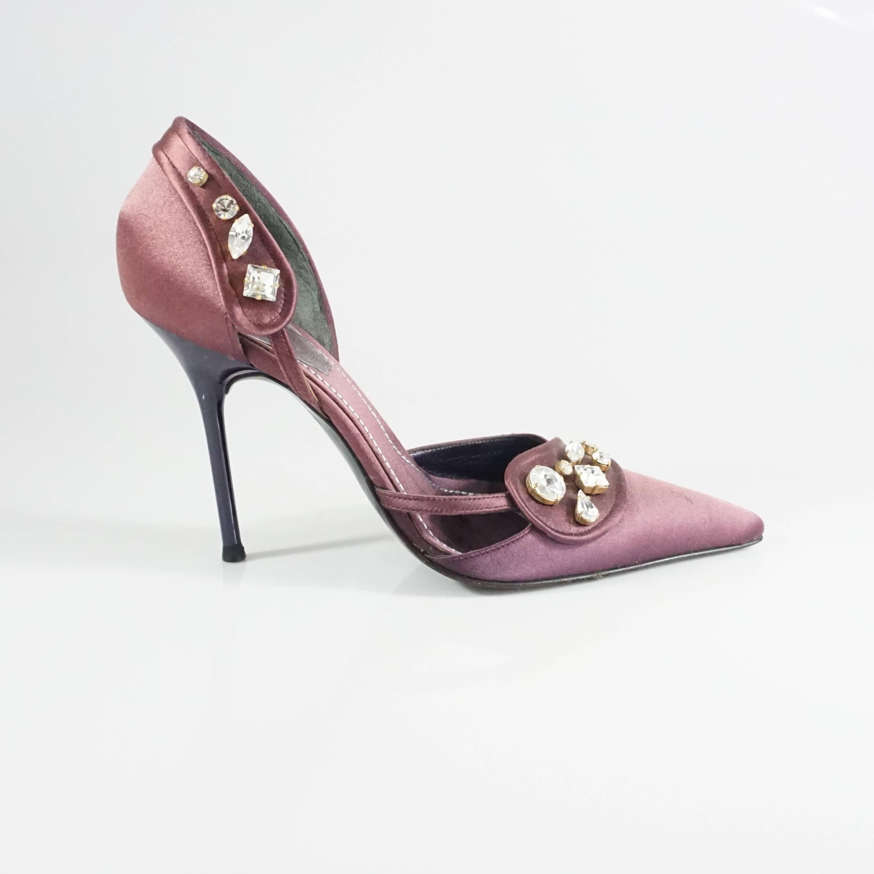 These Rene Caovilla eggplant satin heels are pointed toe with large rhinestones clusters on it. They are in good condition with a few minor scratches on the satin and minimal botton wear. Size 35.5. 

Heel Height: 4"