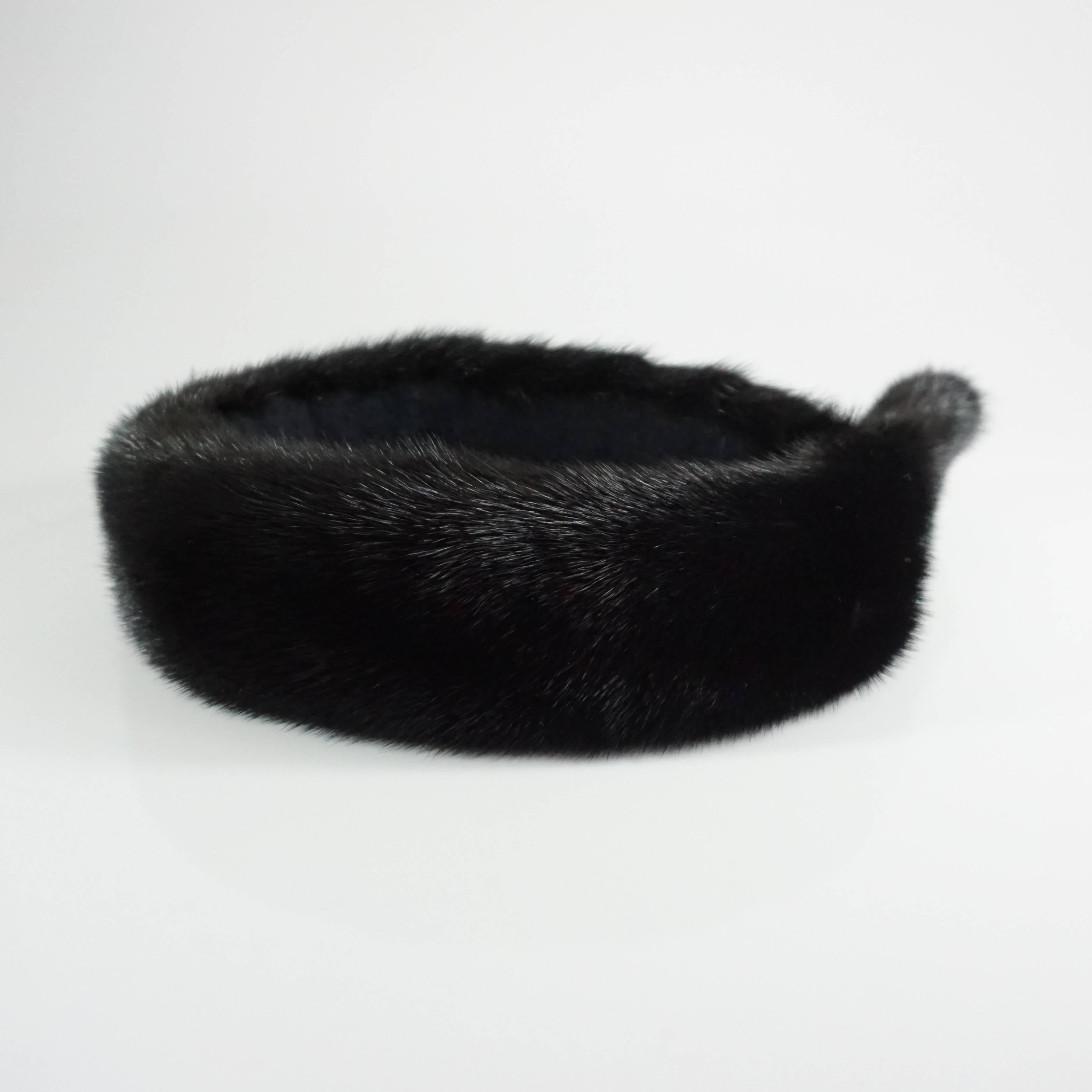 This Birger Christensen dark brown mink head piece has such a rich color, it almost pasts for black. The piece sits on top of the head and has a rhinestone pendant. The piece is in excellent condition with minimal wear to the fur.