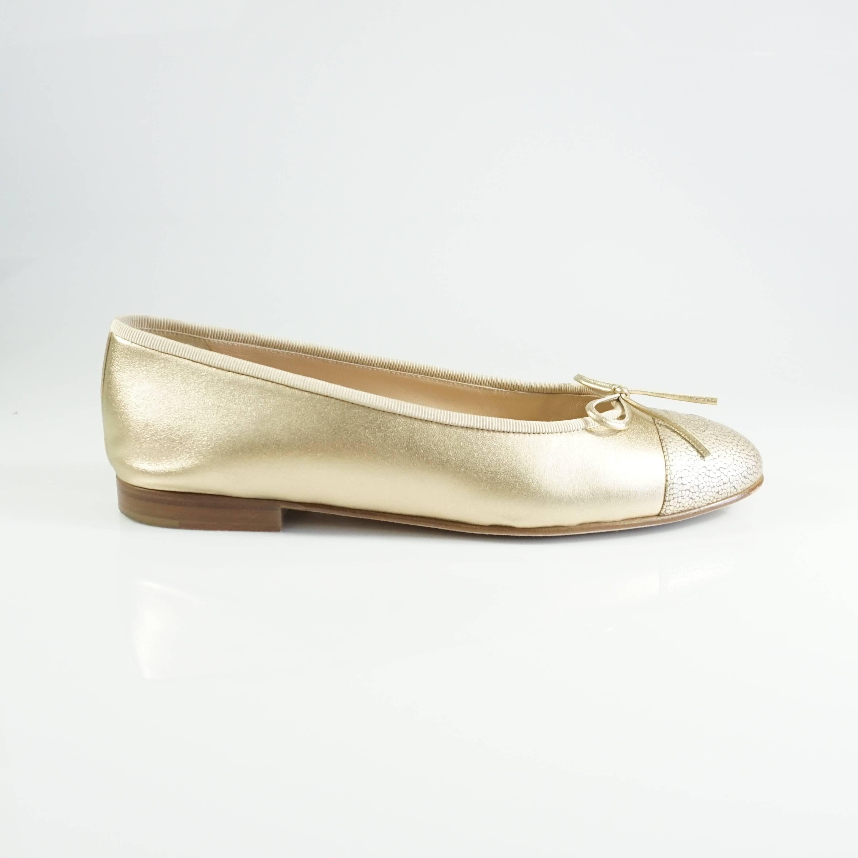 These Chanel flats are made of gold leather and are embossed to appear as stingray on the cap toe. The flats feature the signature stitched "CC" logo and small bows. These shoes are in excellent condition with minimal bottom wear and one