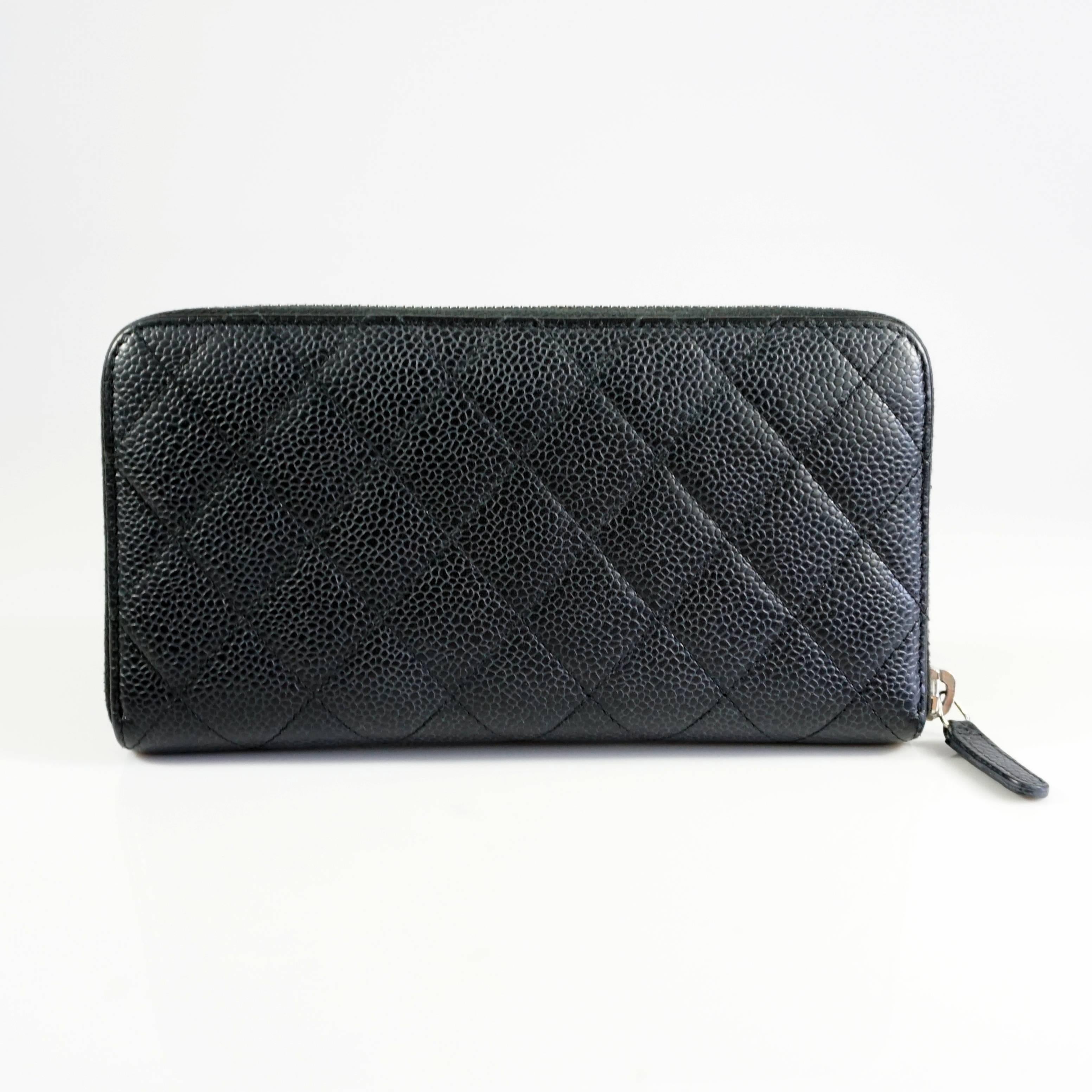 This classic Chanel wallet is black and is made of quilted caviar leather. The wallet has silver hardware and features a 
