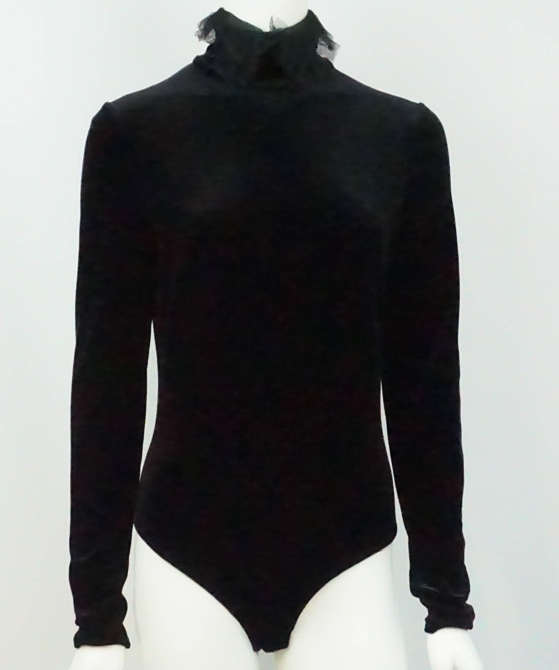 Christian Dior Black Velvet Bodysuit - 42 - Circa 70's  The blast from the past Dior Black velvet bodysuit has a high turtleneck collar with a lace detail. It has a back zipper as well as two snaps at the crotch area.  This velvet piece is a must