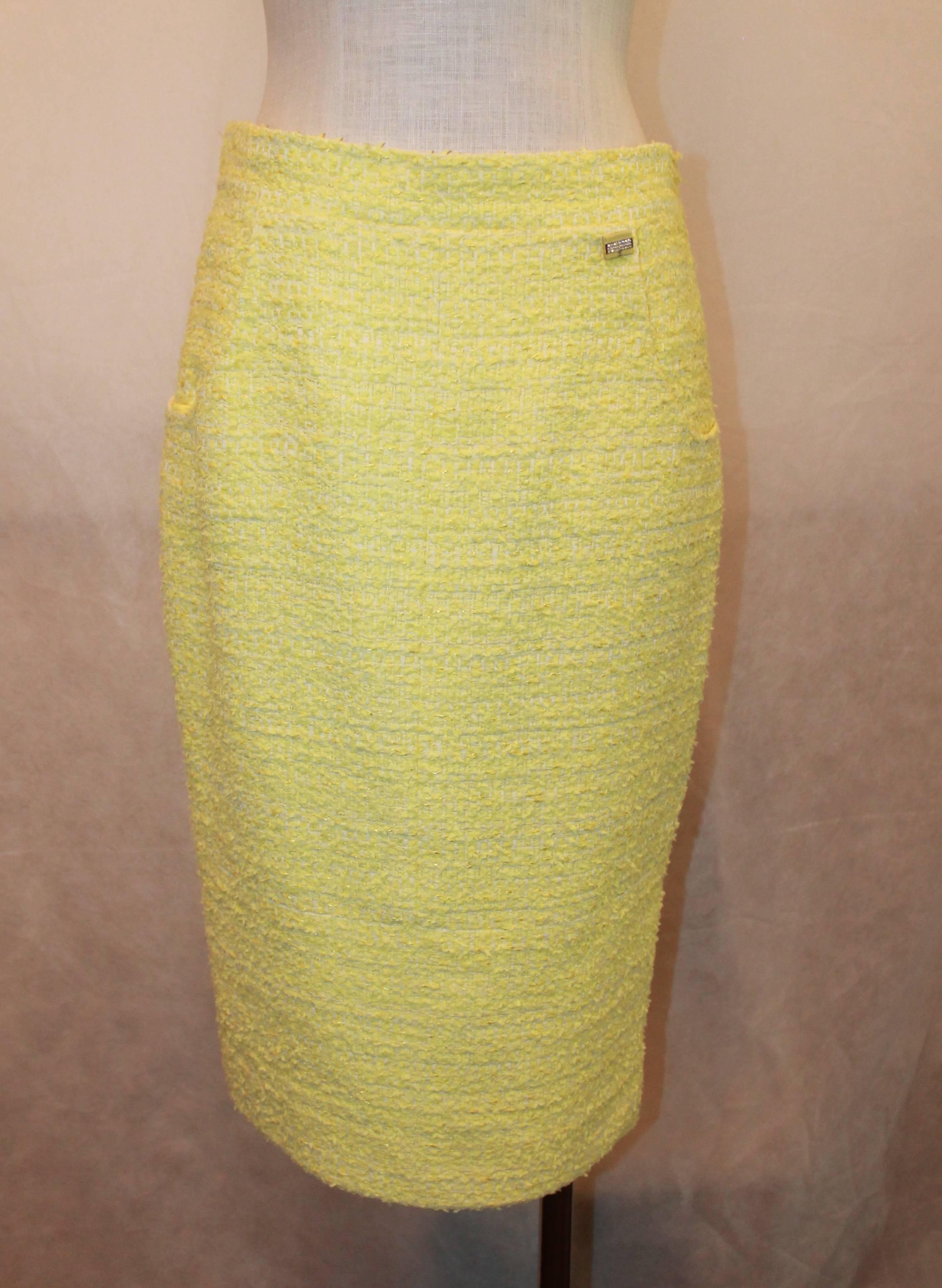 Chanel Yellow & Lime Tweed Skirt with 2 Pockets - 40.  This Chanel yellow tweed skirt has a middle seam, two front pockets, and a back center zipper.  it has one rectangle emblem with yellow enamel, white rhinestones, and the Chanel logo in