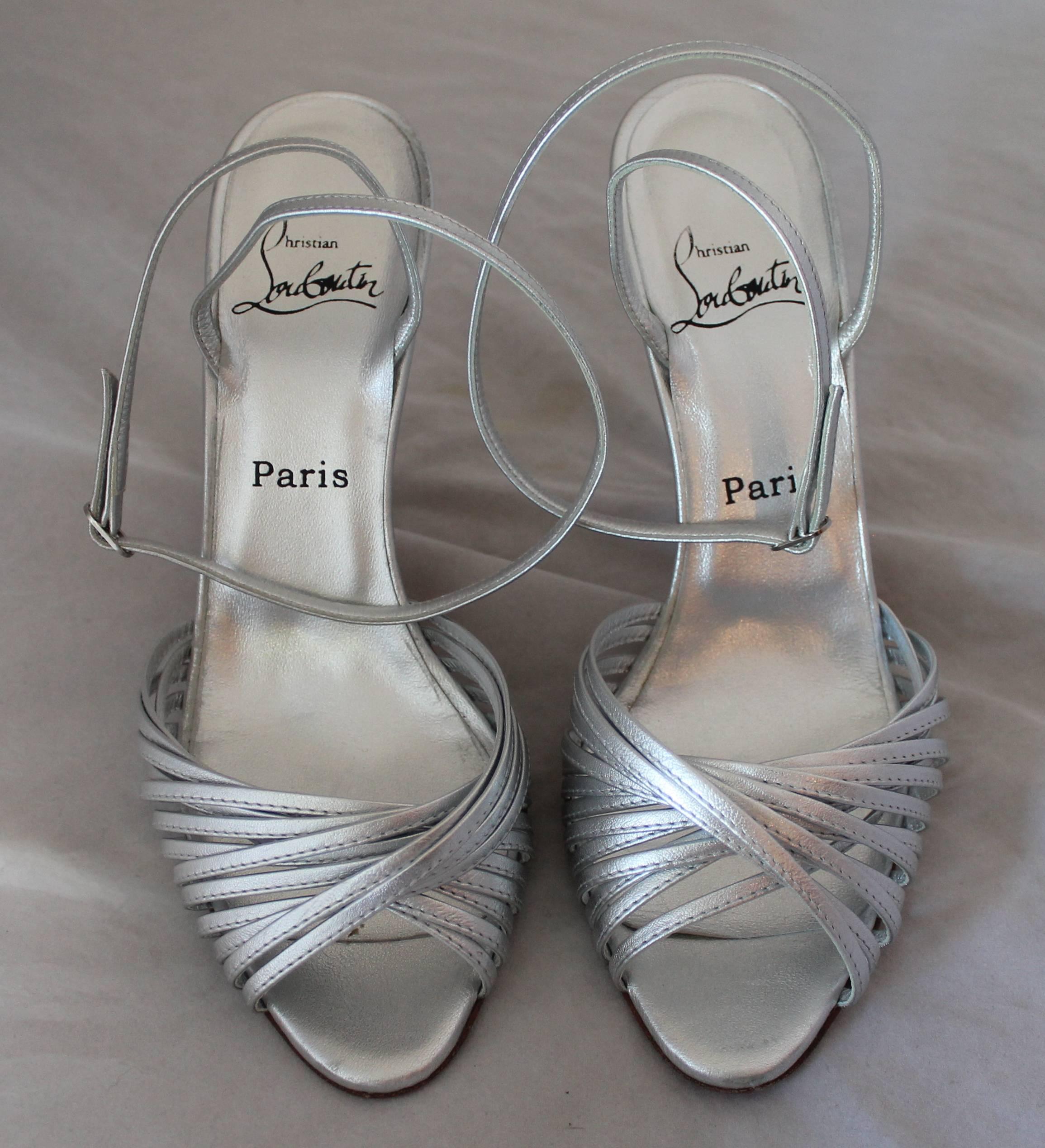 Christian Louboutin Silver Leather Ankle Strap Sandal - 39.5.  These beautiful shoes are barely worn, in excellent condition.  They have an elegant ankle strap and a front crossover multi strap.

Measurements:
Heel: 4