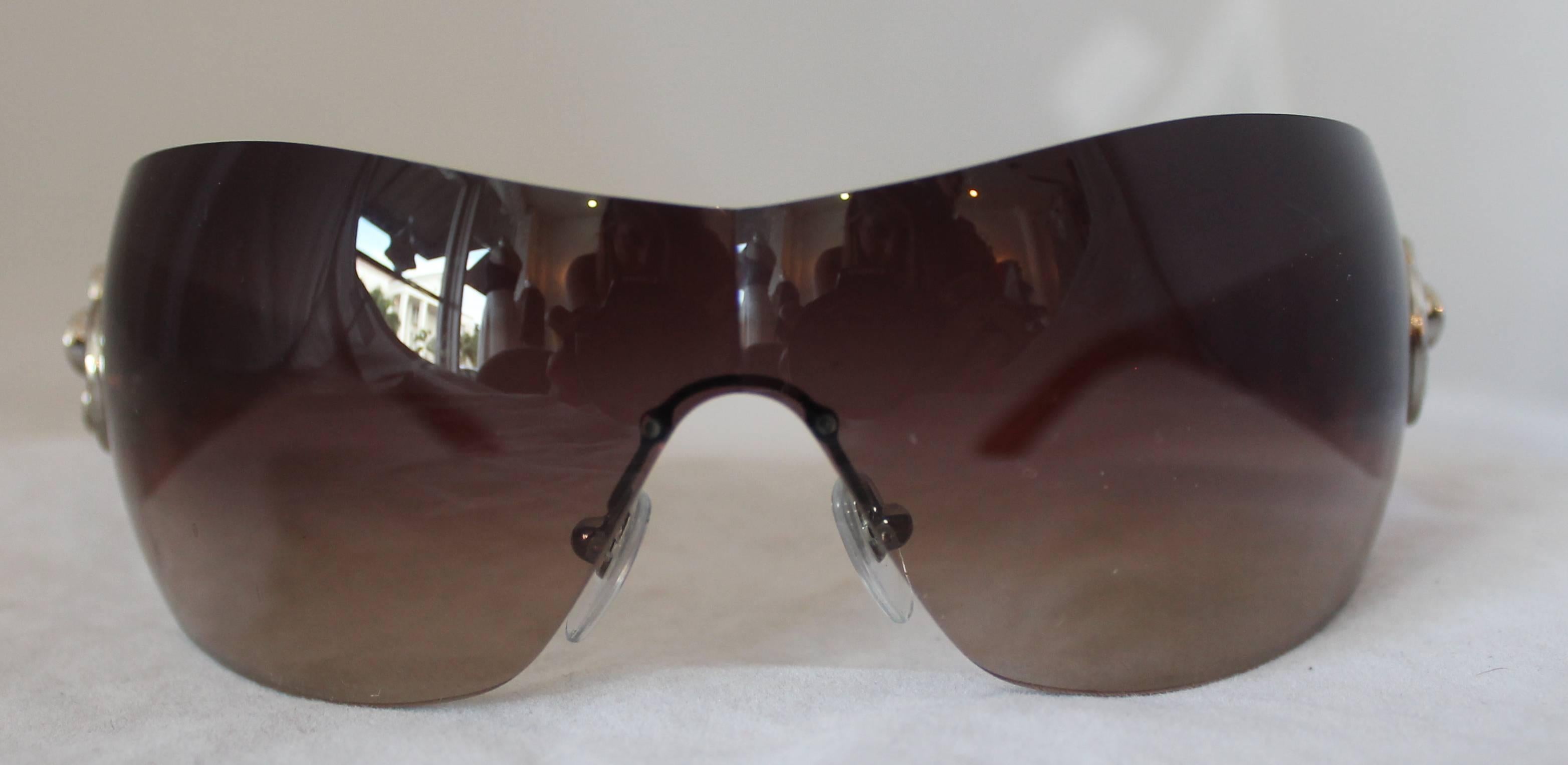 Bulgari Light Brown Sunglasses w/ Crystal Flower and Rhinestone Detail.  These sunglasses are in good condition with minor wear to the lenses.  They have graduated lenses, fading from darker to lighter from top to bottom.  They are embellished with