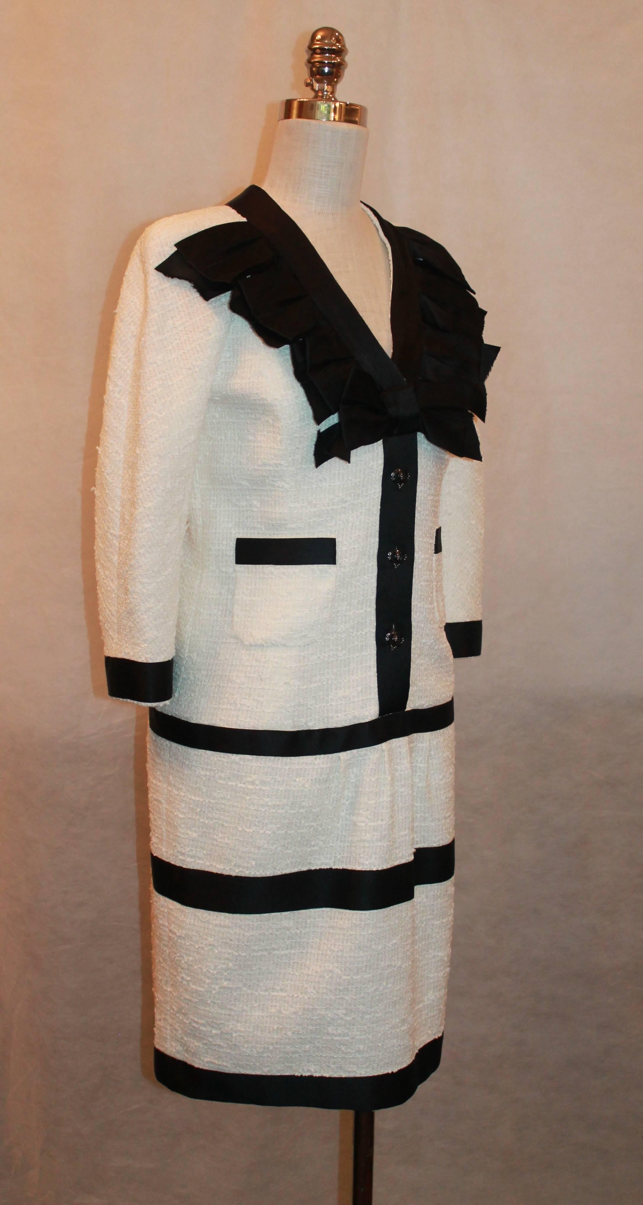 2009 Chanel Black and White Tweed  3/4 Sleeve Dress with Ribbon Trim - 40 This  dress is in excellent condition and is a Nylon-Cotton- Wool blend.  There is a black and white design on the collar. The button is made up of a CC black enamel and pearl