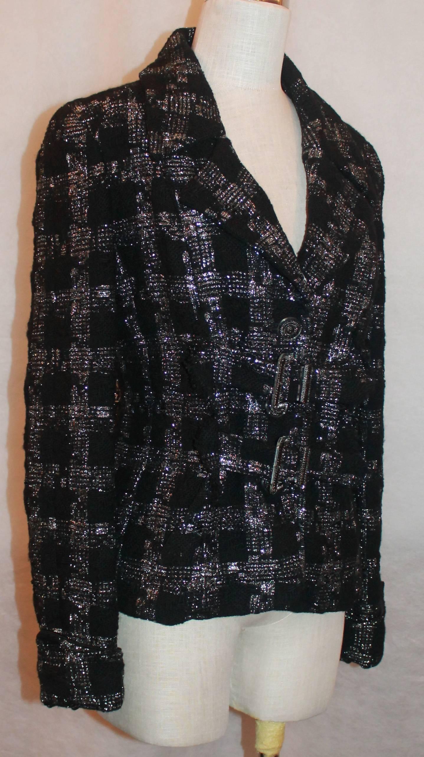 Chanel Tweed Jacket with Two Front Pockets and Belts - 38
This Chanel Jacket is in excellent condition. It has cuffed sleeves and a buckle in the back. The buttons are Lucite with palladium and graphite with rhinestones and the 