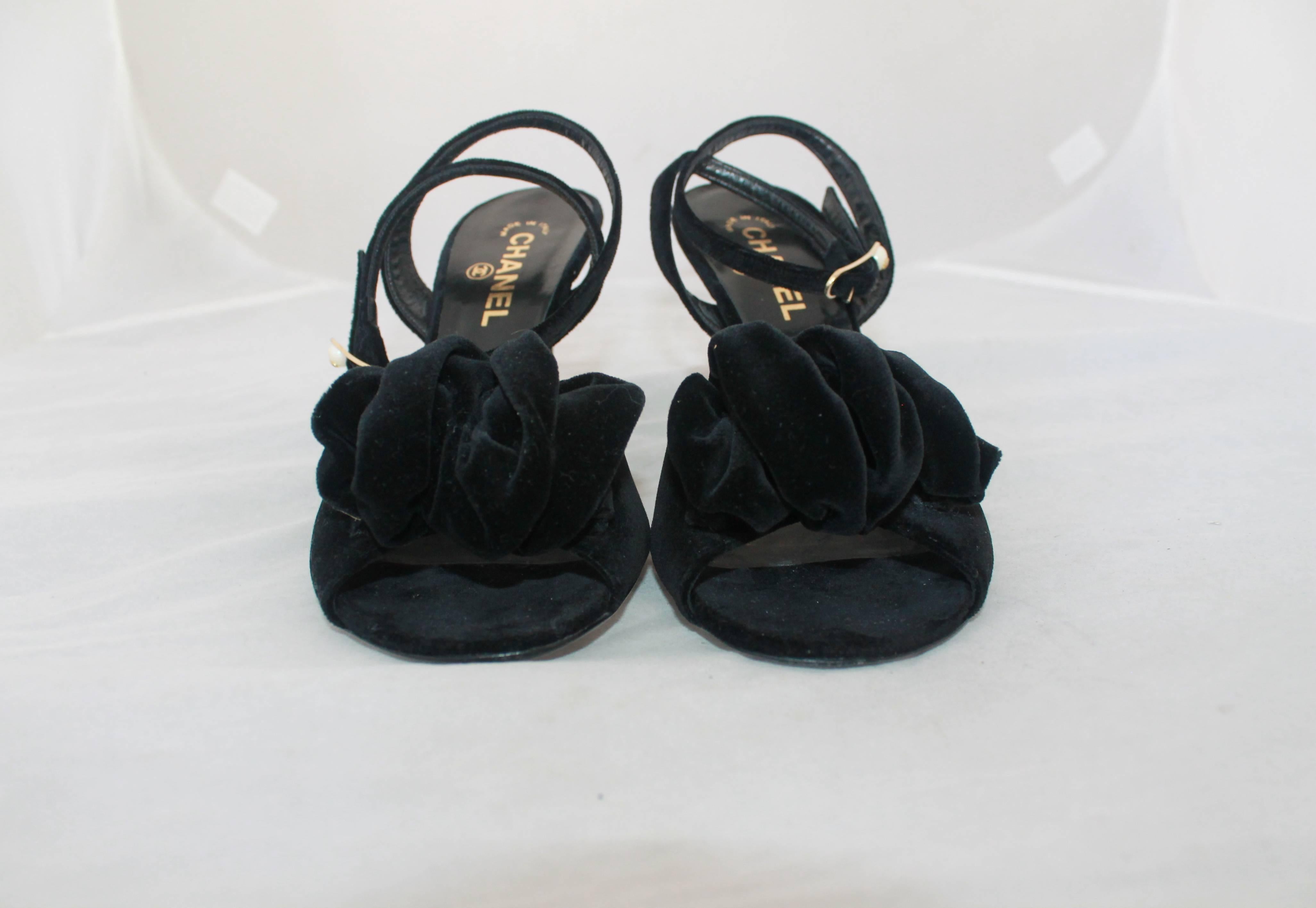 Chanel Black Velvet Open-Toe Strappy Heel w/ Floral Cluster - 39.5.  These elegant heels are in excellent condition with minor wear to the sole.  They have a crisscross styled ankle strap with a pearl with  