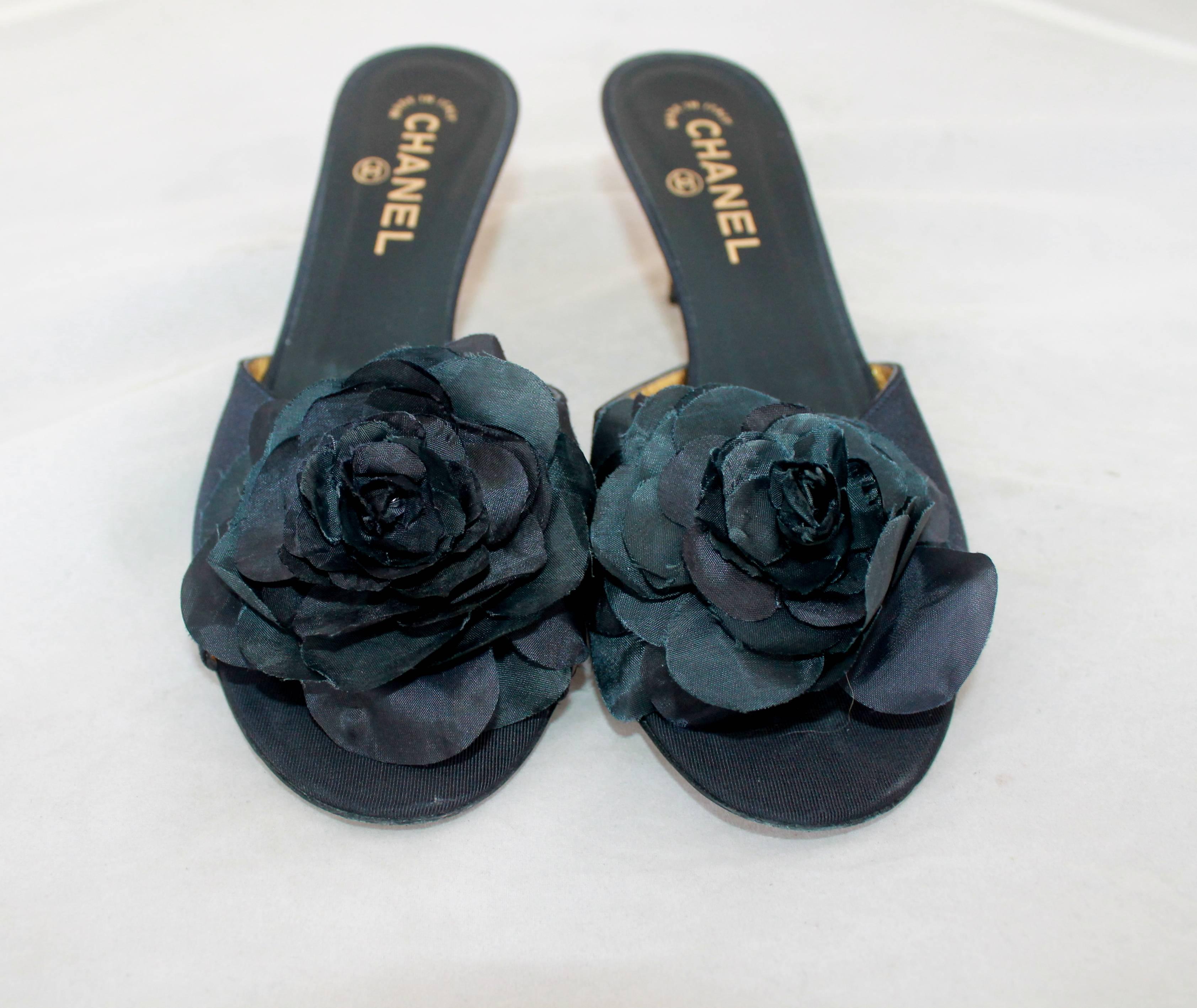 Chanel Navy Silk Faille Slide w/ Camellia & Geometric Etched Gold Heel - 40.  These slides are in excellent condition with slight wear to the sole.  They have a large, elegant silk camellia on the front.  They have a unique geometric, etched gold