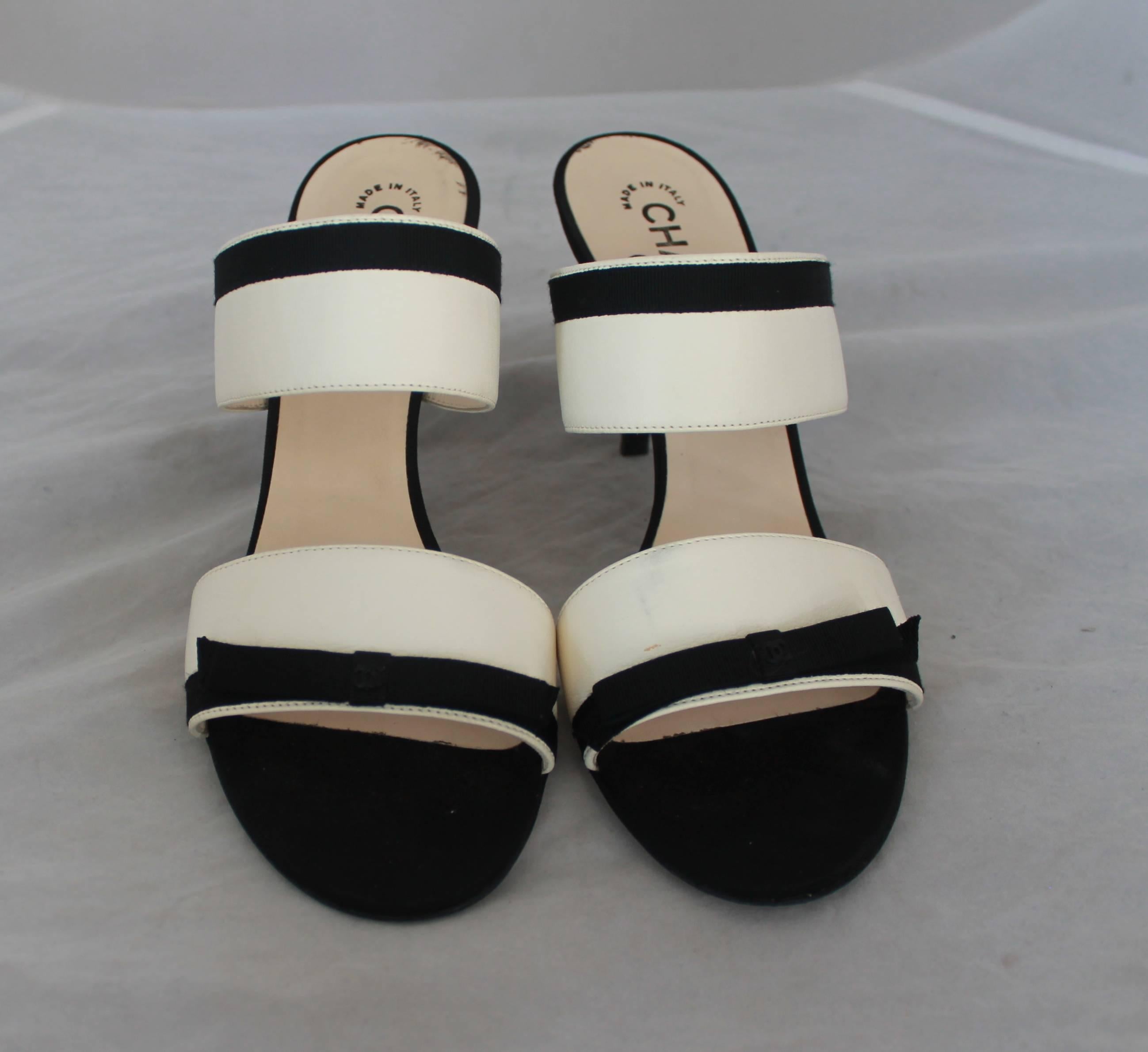 Chanel Ivory Lambskin Double Strap Heels w/ Black Grosgrain Ribbon Trim - 40.  These lovely double strap heels feature smooth ivory lambskin, black ribbon trim, and a black 