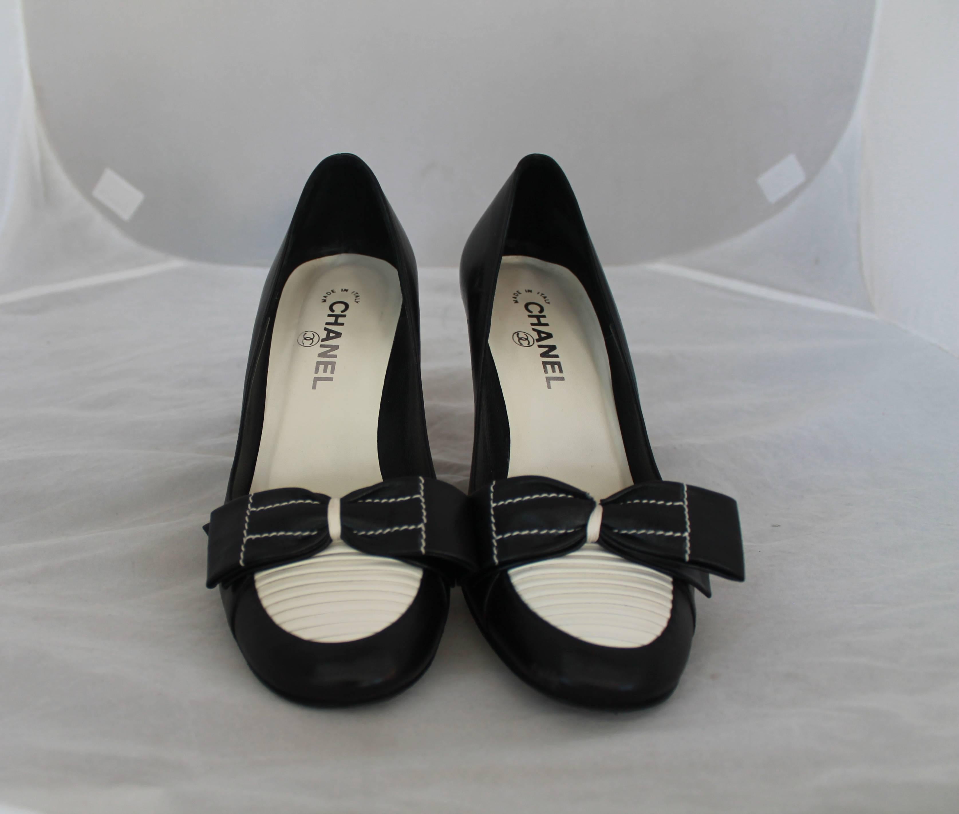 Chanel Black & Ivory Leather Loafer Style Pumps - 39.5.  These beautiful pumps are in excellent condition with visible bottom wear, but minimal outside wear.  They have front pleating and a large bow with white stitching as shown in Image