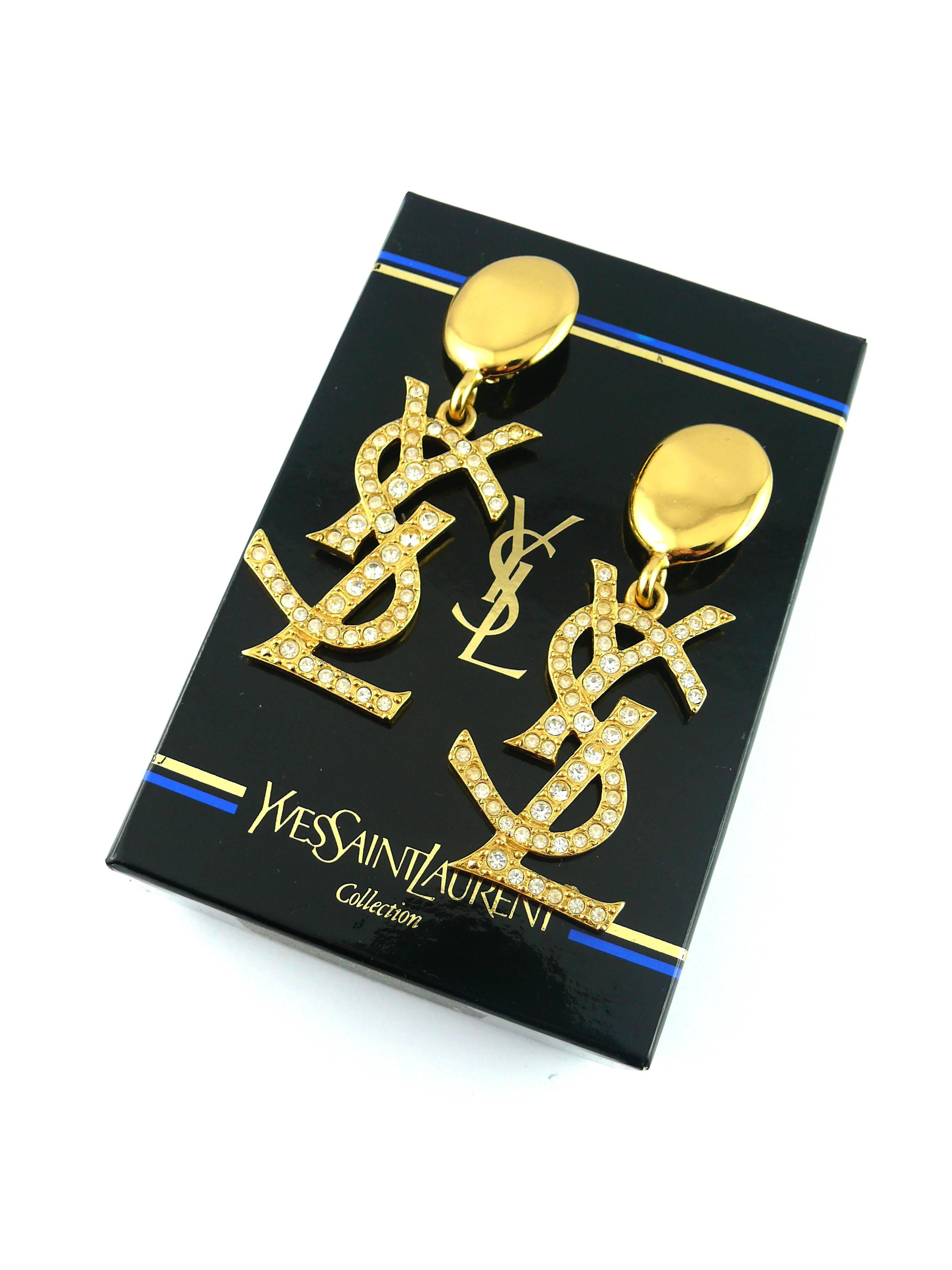 YVES SAINT LAURENT rare vintage gold toned iconic logo massive dangling earrings (clip on) with rhinestone embellishement. 

Hard to find and collectable item ! 

Embossed YSL Made in France.

Indicative measurements : length approx. 8.1 cm (3.19