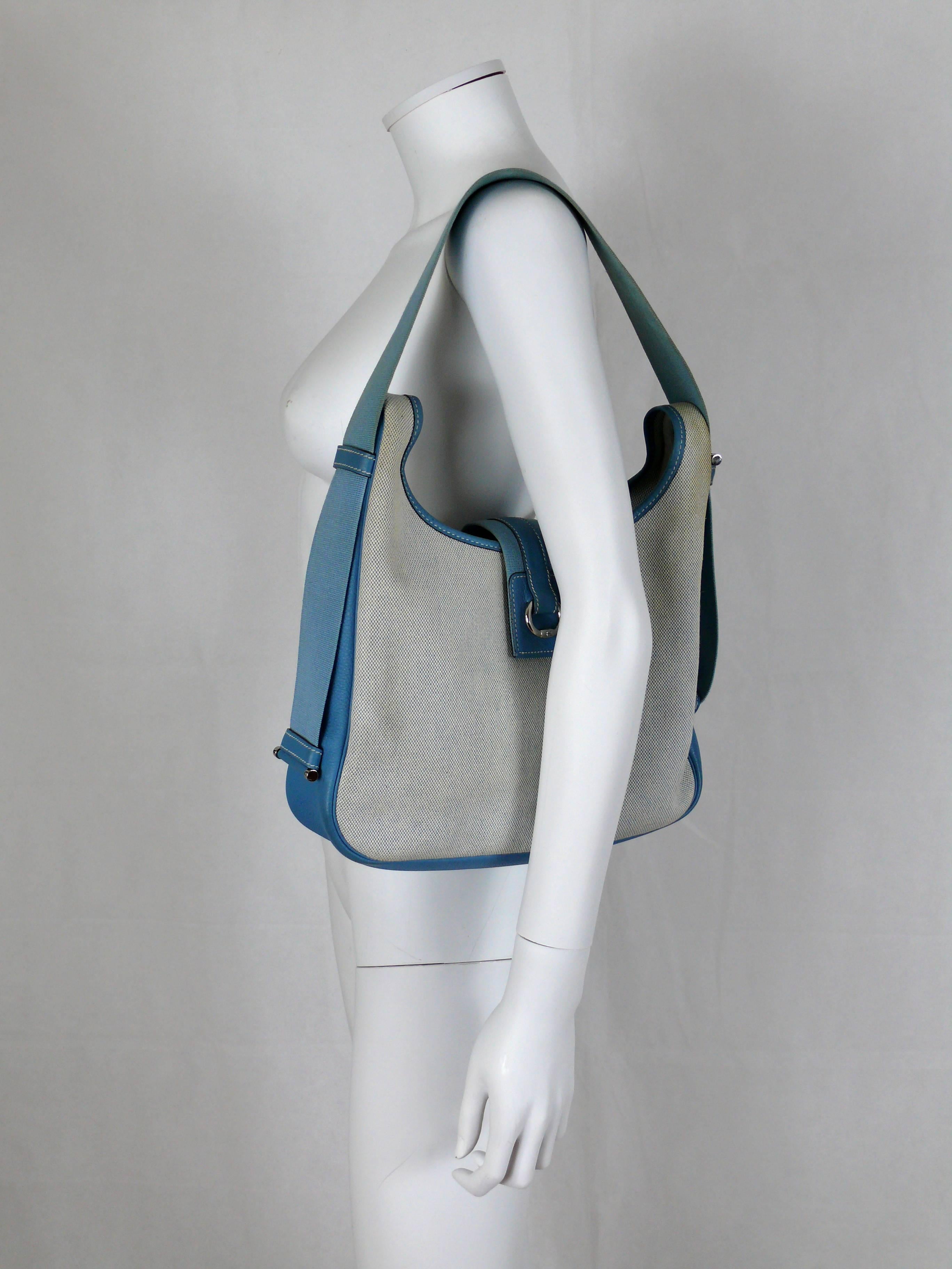 HERMES vintage beige canvas Tsako bag with silver tone hardware and blue jean blue Togo leather.

Two interior wall pockets (one with zip).

Flat adjustable shoulder strap.

Front snap button closure embossed with letter "H".

Letter date