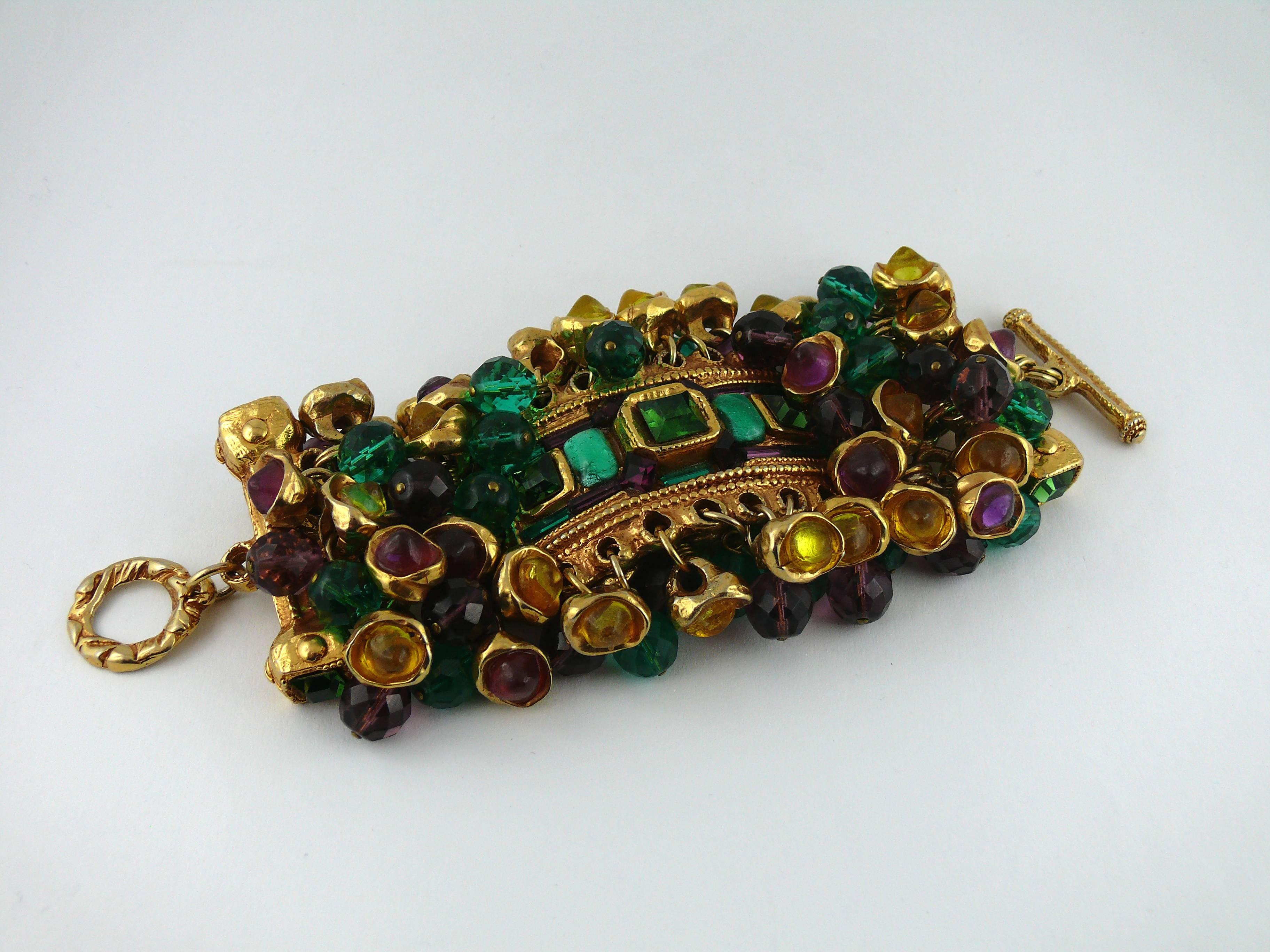 KALINGER vintage massive opulent jewelled cuff bracelet featuting multicolored faceted glass beads and resin cabochon charms in a gold tone setting.

Circa 1980.

T-bar closure.

Marked KALINGER.

JEWELRY CONDITION CHART
- New or never worn : item