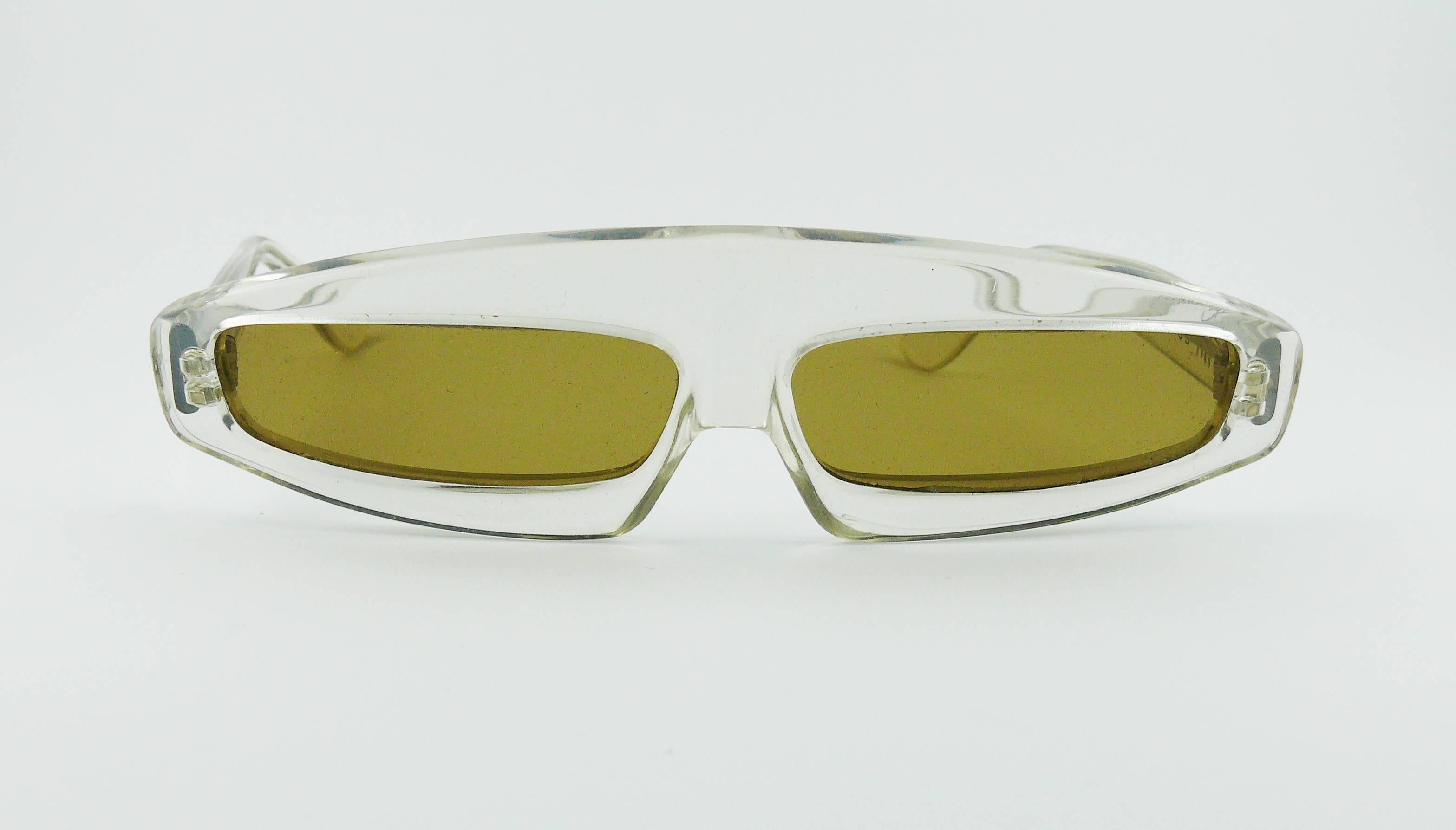 THIERRY MUGLER vintage rare iconic COSMOS sunglasses.

A similar model is photographied in VOGUE Paris May 1979.

These sunglasses are made of thick transparent lucite with silver toned structure. Lenses are in smoked color acrylic.

Signed TM