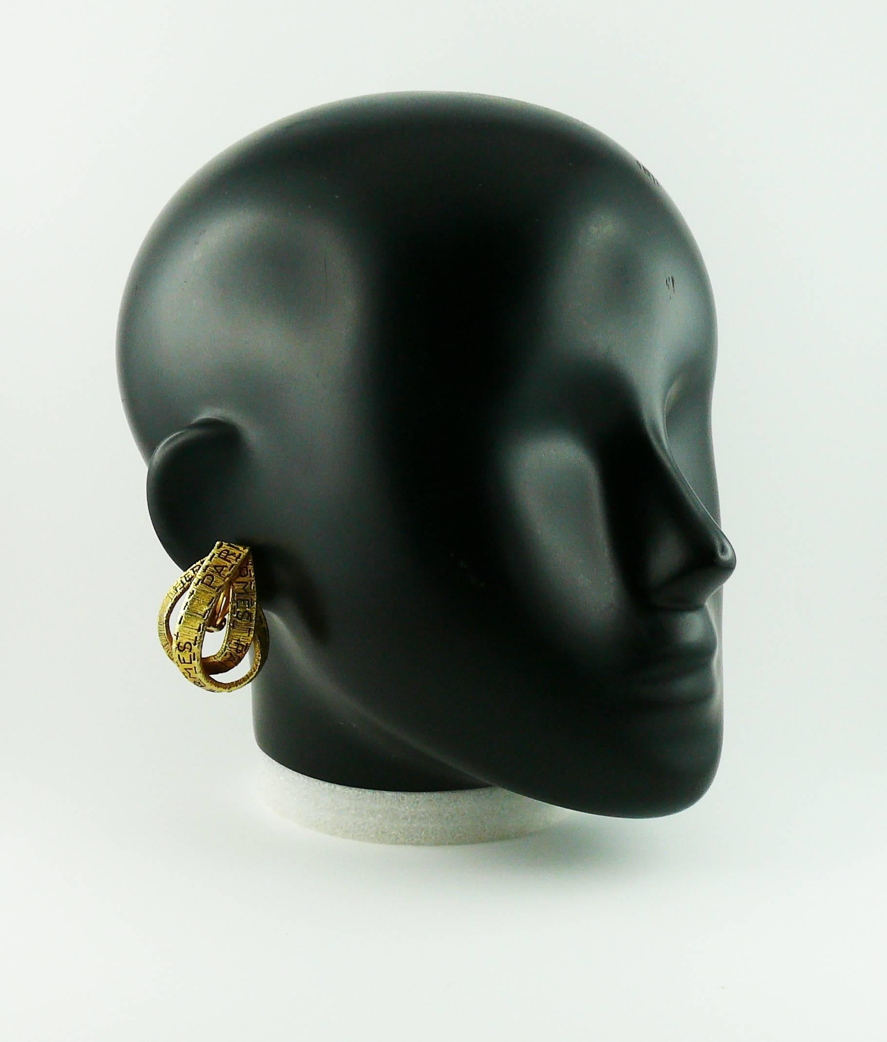 HERMES vintage gold toned ribbon motif clip-on earrings with trompe l'oeil stitch detail.

Marked HERMES Paris Bijouterie Fantaisie.

JEWELRY CONDITION CHART
- New or never worn : item is in pristine condition with no noticeable imperfections
-