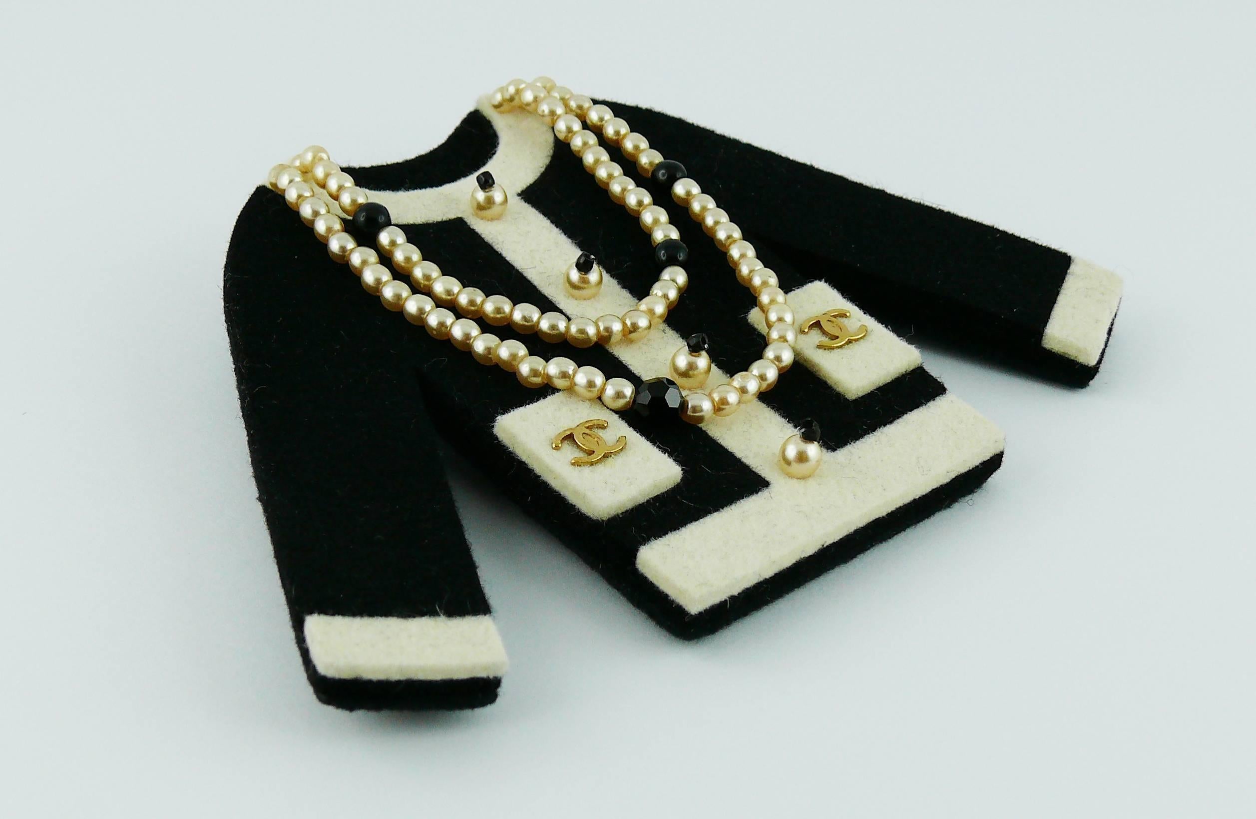 CHANEL large iconic little black jacket felt brooch with faux pearl sautoir necklace and gold tone CC monogram on front pockets.

Fall/Winter 2002.

Bar pin fastening.

Marked CHANEL 02 A Made in France.

Indicative mesaurements : length