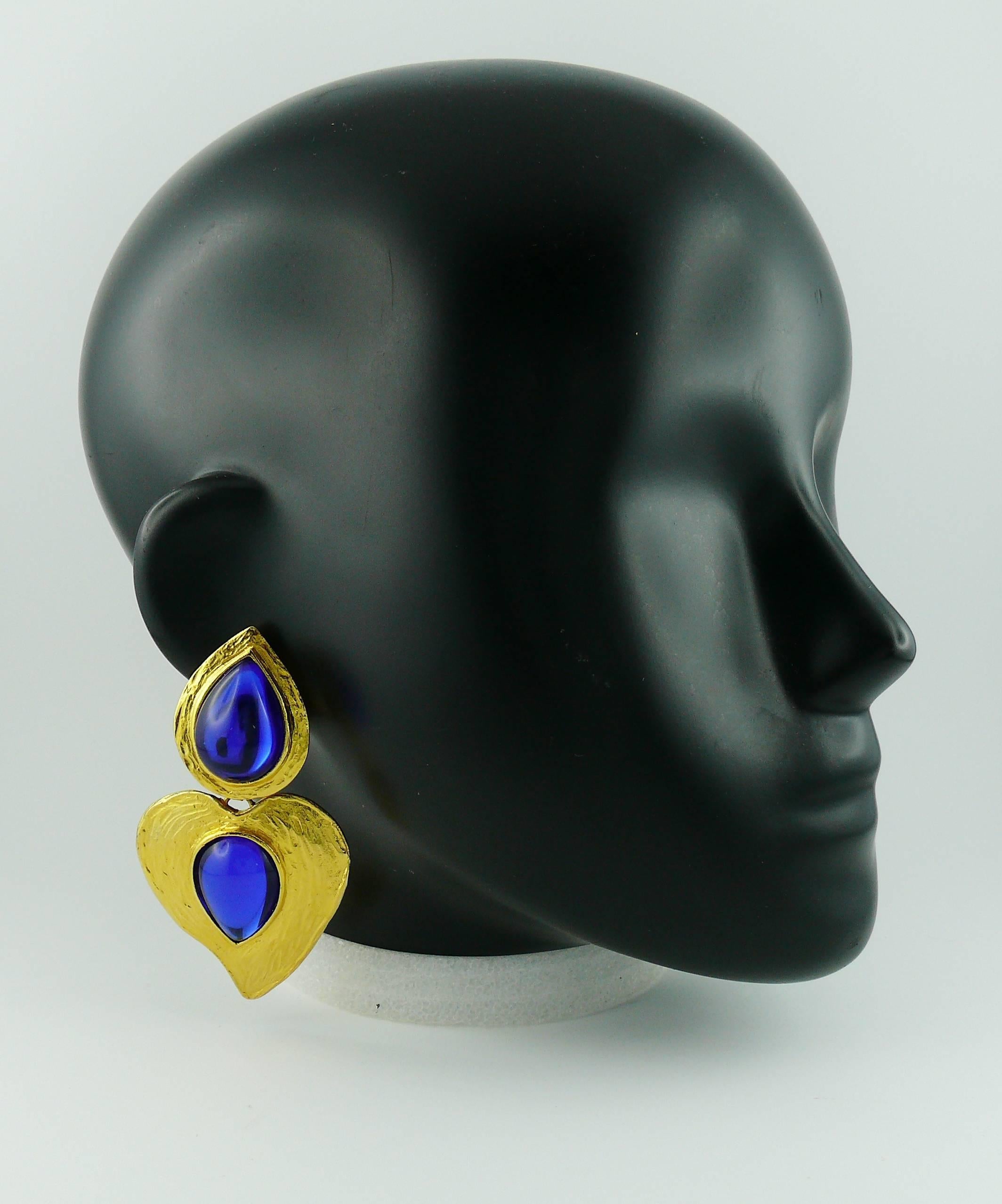 YVES SAINT LAURENT vintage textured gold tone heart dangling earrings (clip-on) featuring two deep blue glass cabochons.

This earring model is a rare find !

Marked YSL Made in France.

Indicative mesaurements : length approx. 8.2 cm (3.23 inches)
