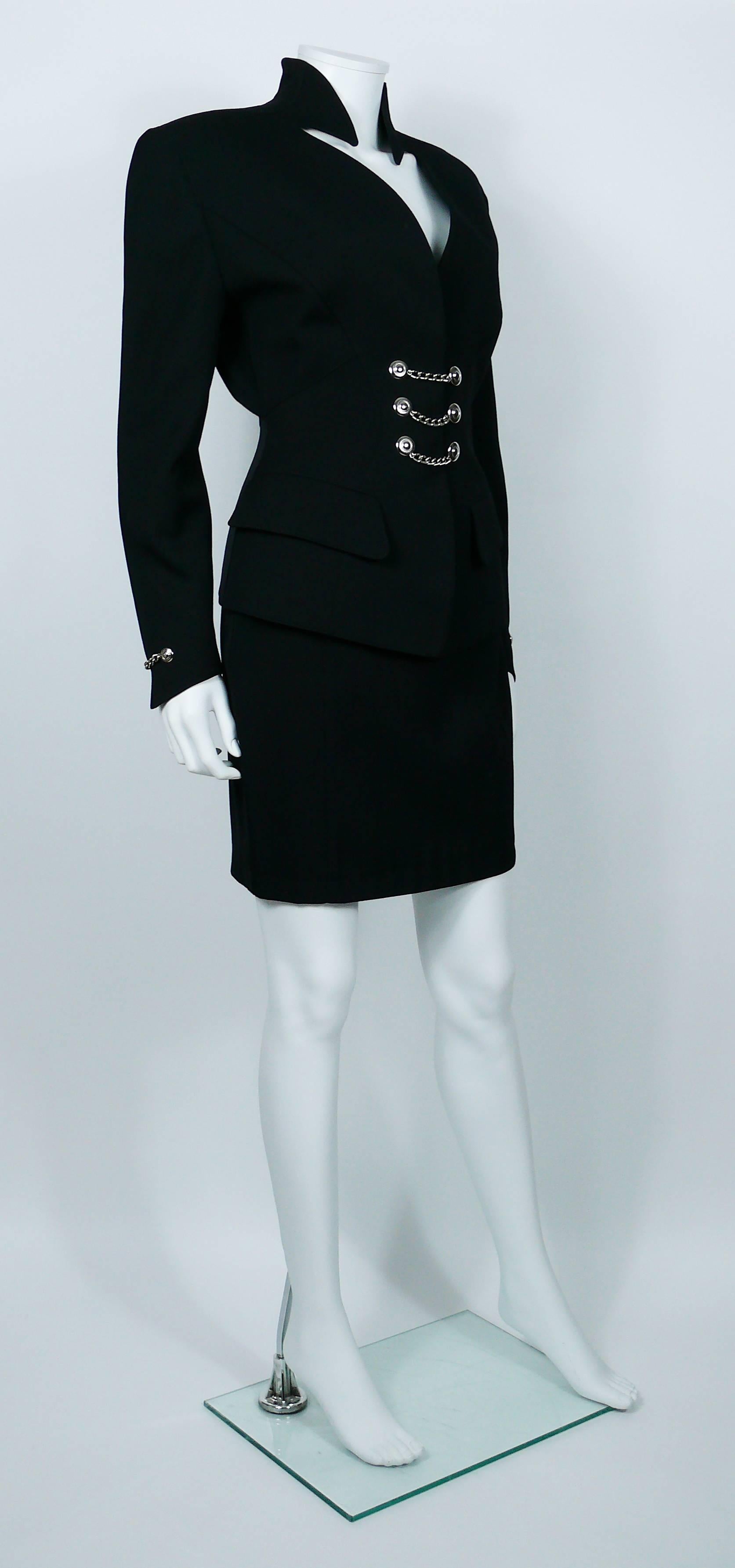 THIERRY MUGLER vintage black wool skirt suit.

Tailored jacket with typical MUGLER's cut. Deep neckline and gorgeous graphic collar. Two flap pockets. Snap closure at the front embellished with three silver toned chains. Shoulder pads. Jacket is