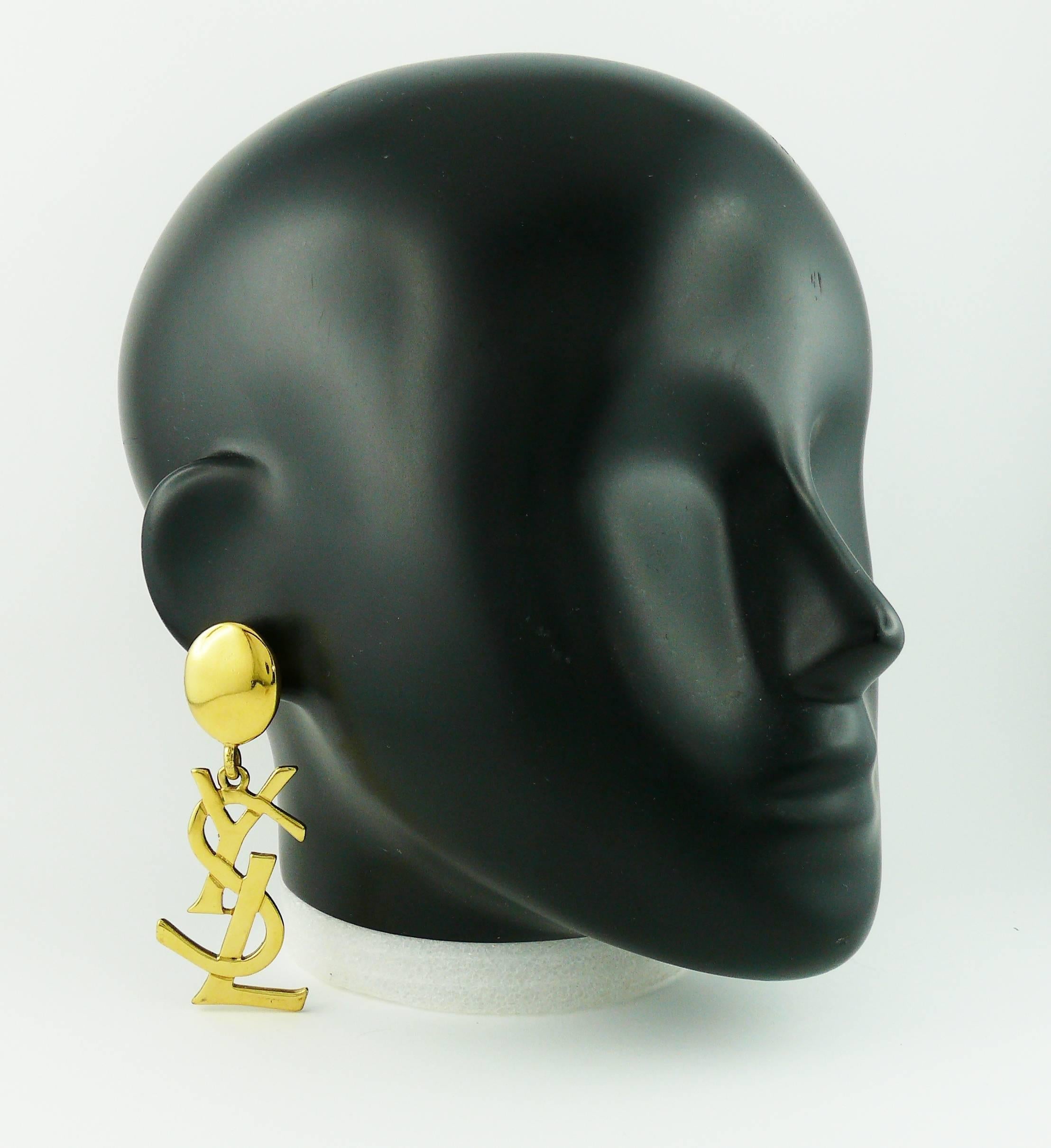 YVES SAINT LAURENT massive vintage gold toned iconic logo dangling earrings (clip on).

Rare and collectable item !

As seen on SAMANTHA JONES in SATC 2.

Marked YSL Made in France.

JEWELRY CONDITION CHART
- New or never worn : item is in
