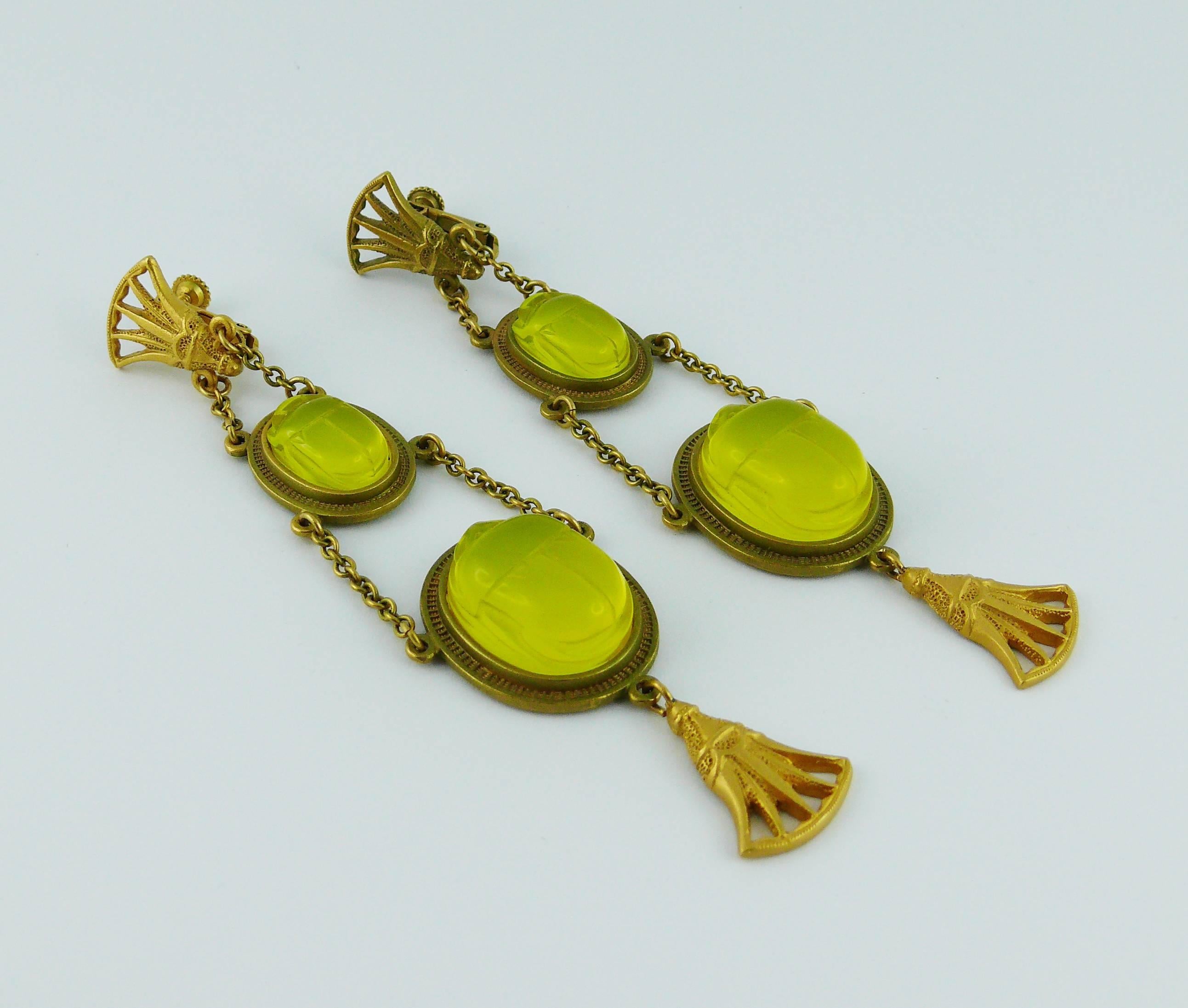 CHRSITIAN DIOR by JOHN GALLIANO Egyptian revival dangle earrings (clip-on) featuring antique ornaments and lucite scarabs in a matte gold tone setting.

The scarabs are an irridescent yellow/lime which changes in different light and upon