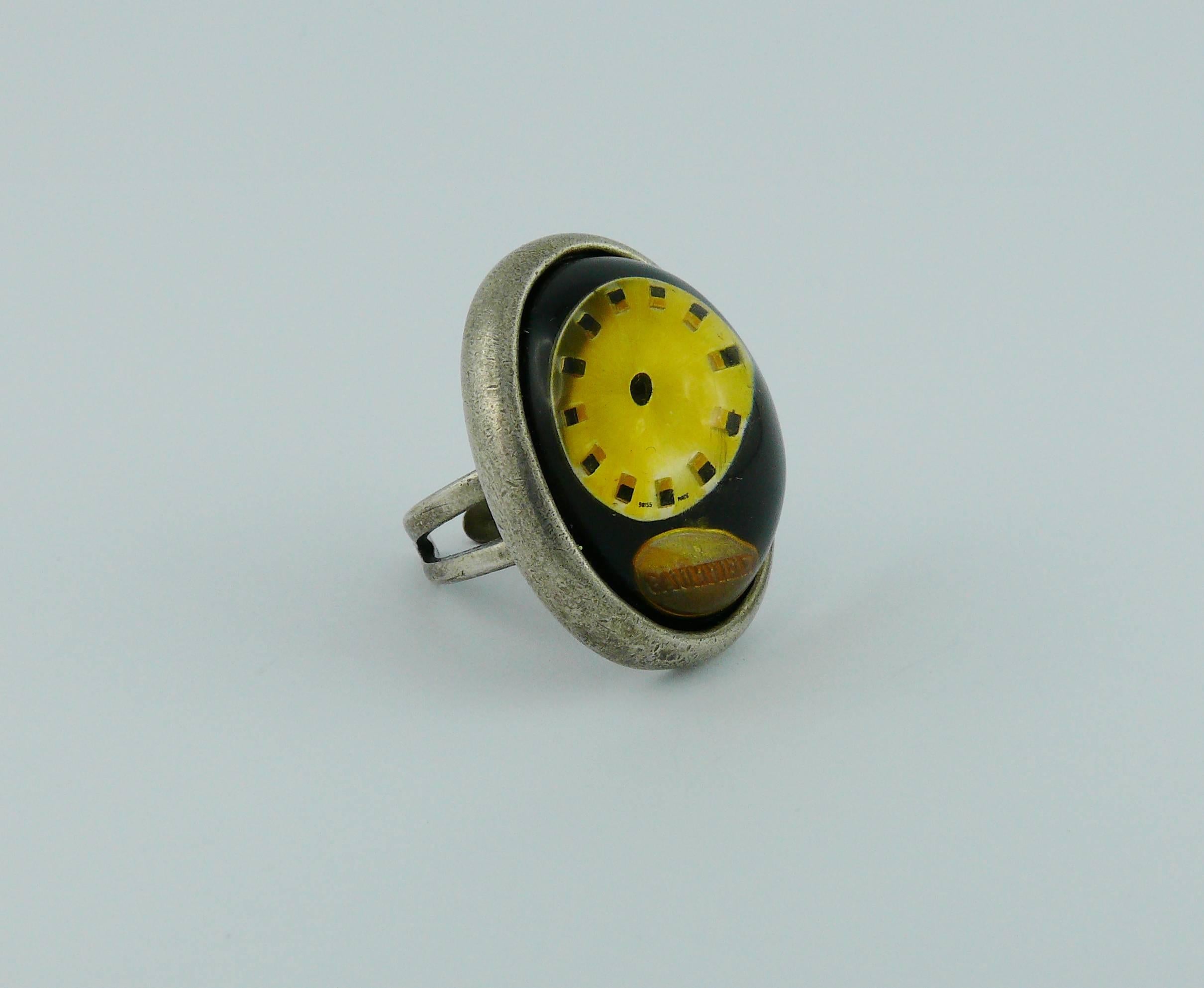 JEAN PAUL GAULTIER vintage clock ring featuring a massive domed resin cabochon in a silver tone with antique patina setting.

Marked GAULTIER.

Indicative measurements : inner circumference approx. 5.03 cm (1.98 inches) / length approx. 3.3 cm (1.30