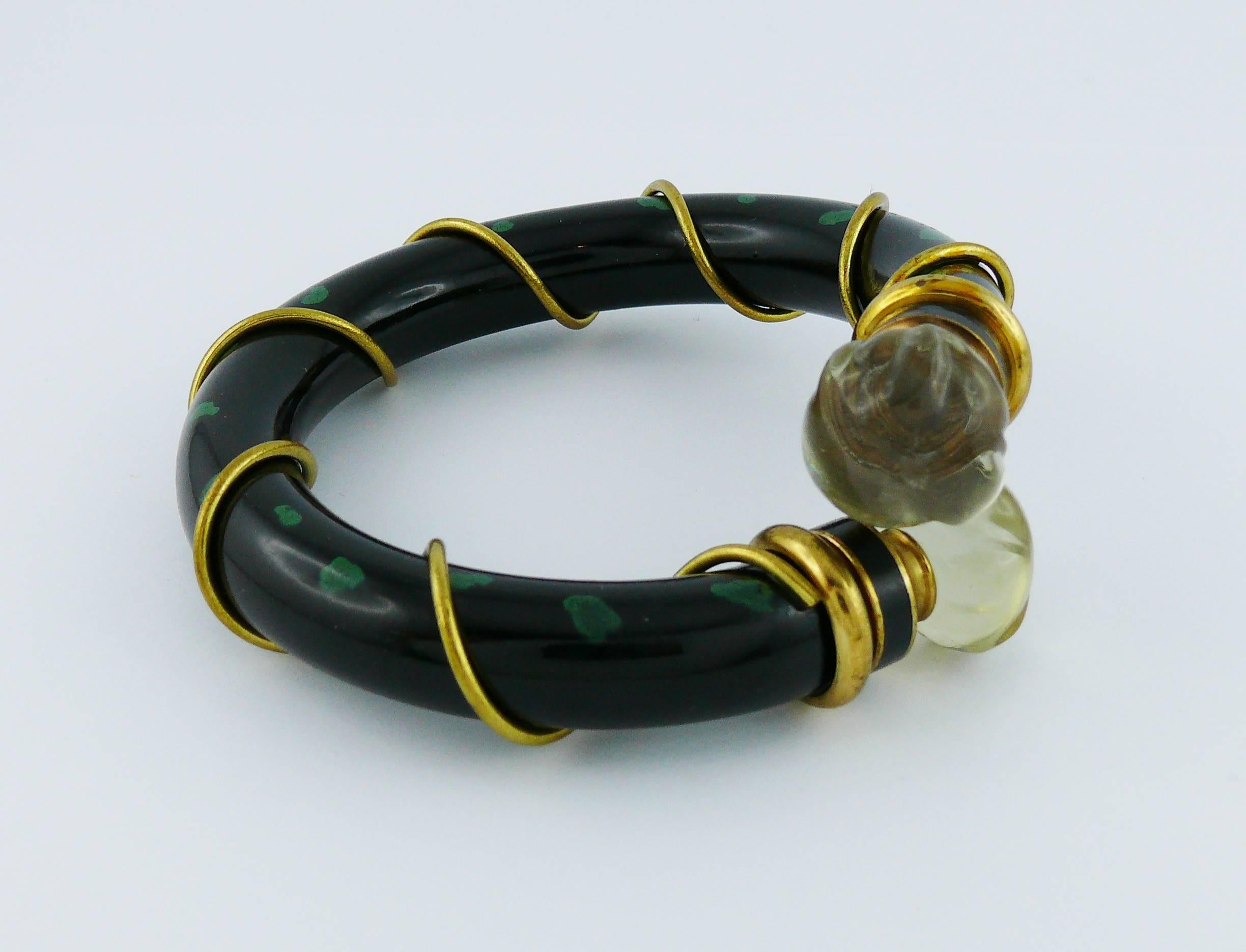 CHRISTIAN DIOR Parfums vintage POISON bracelet.

This bracelet features :
- Refillable tubular structure in black with green spots.
- Gold toned wired hardware.
- Clear resin taps (one tap unscrews).

Marked POISON CHRISTIAN DIOR Paris.

Indicative