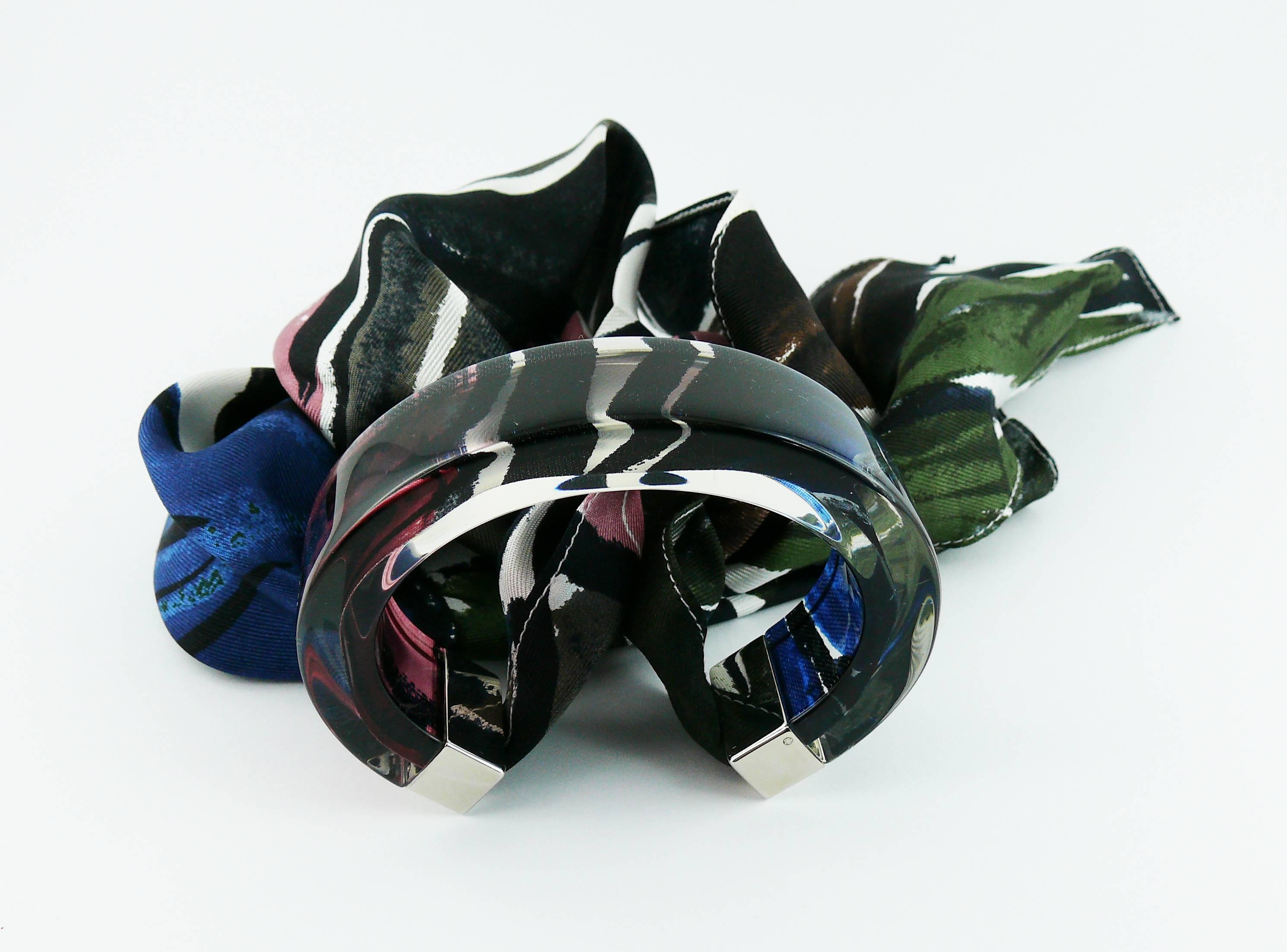 Bracciale in lucite trasparente di Christian Dior con foulard in seta multicolore.

DIOR in rilievo.

Misure indicative: lunghezza massima interna circa 5,9 cm (2,32 pollici) / larghezza bracciale in resina circa 1,9 cm (0,75 pollici).

Viene