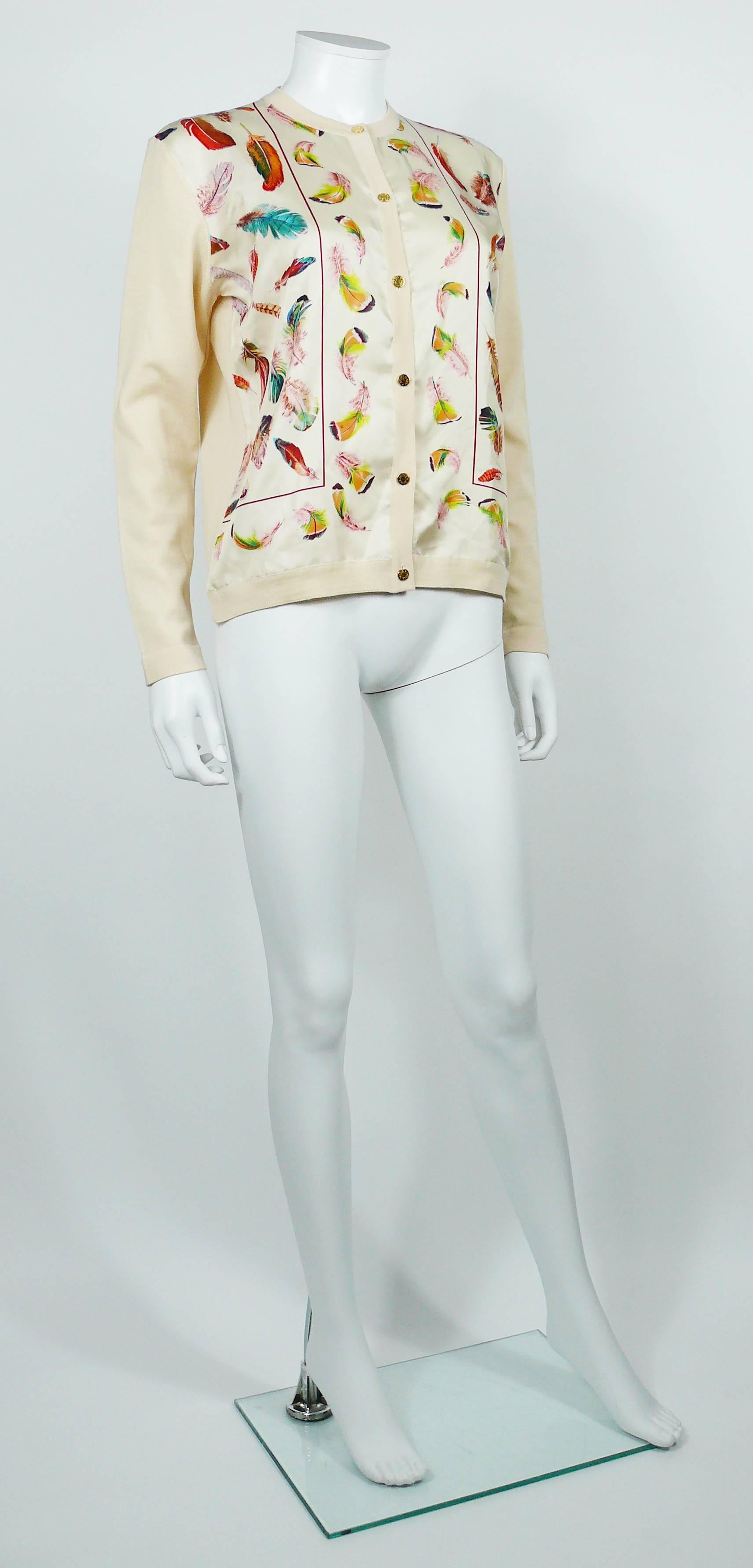 HERMES vintage feather print silk and wool cardigan sweater.

This sweater features :
- Silk panels front with a multicolored feather print on an off-white background.
- Wool sleeves and back.
- Round neck.
- Long sleeves.
- Front buttoning.
- Gold