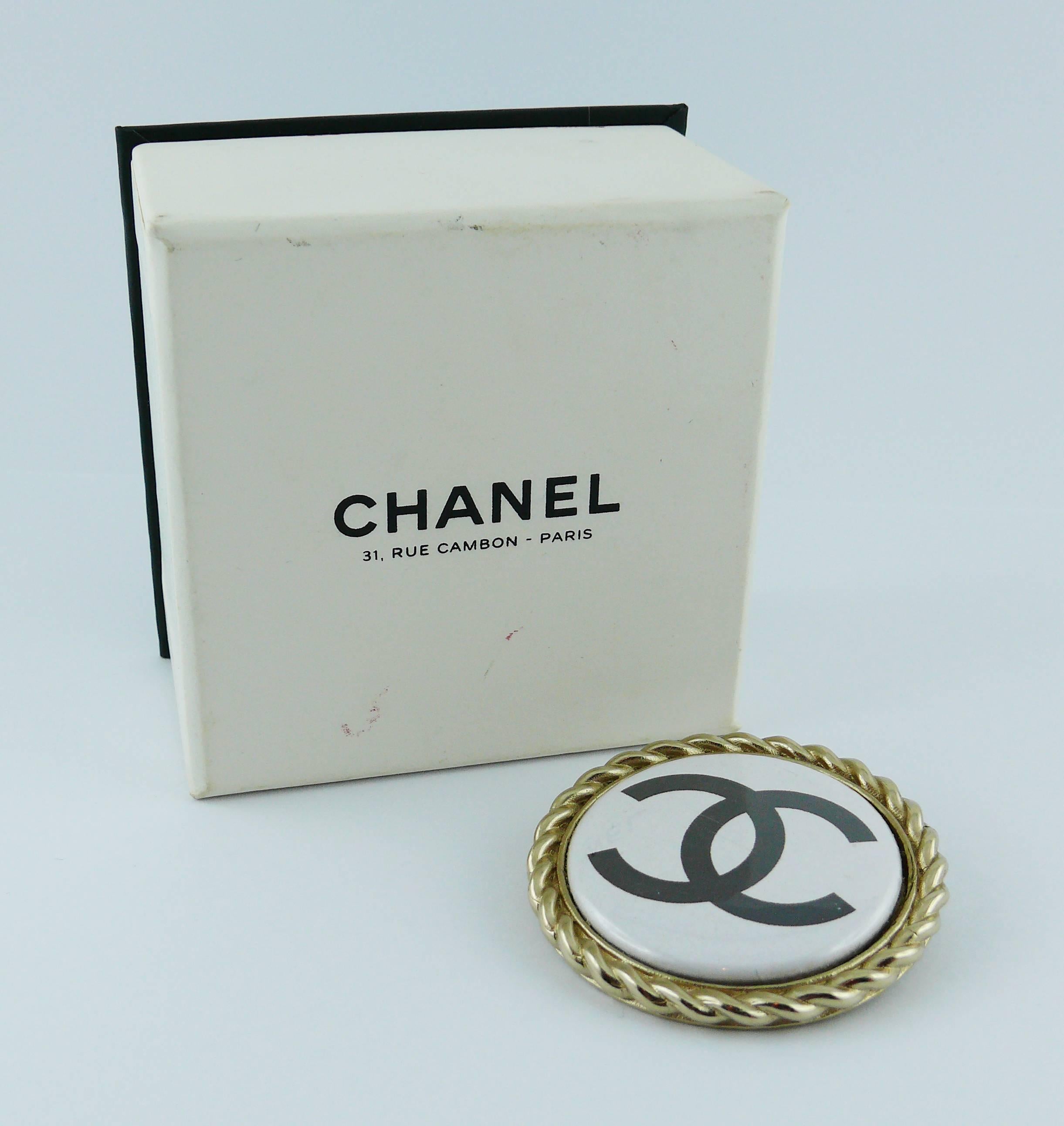 CHANEL brooch featuring a large printed black CC logo in a slightly gold toned setting.

Spring/Summer 2008 Collection.

Marked CHANEL 08 P Made in Italy.

Indicative measurements : diameter approx. 4.5 cm (1.77 inches).

Comes with CHANEL box