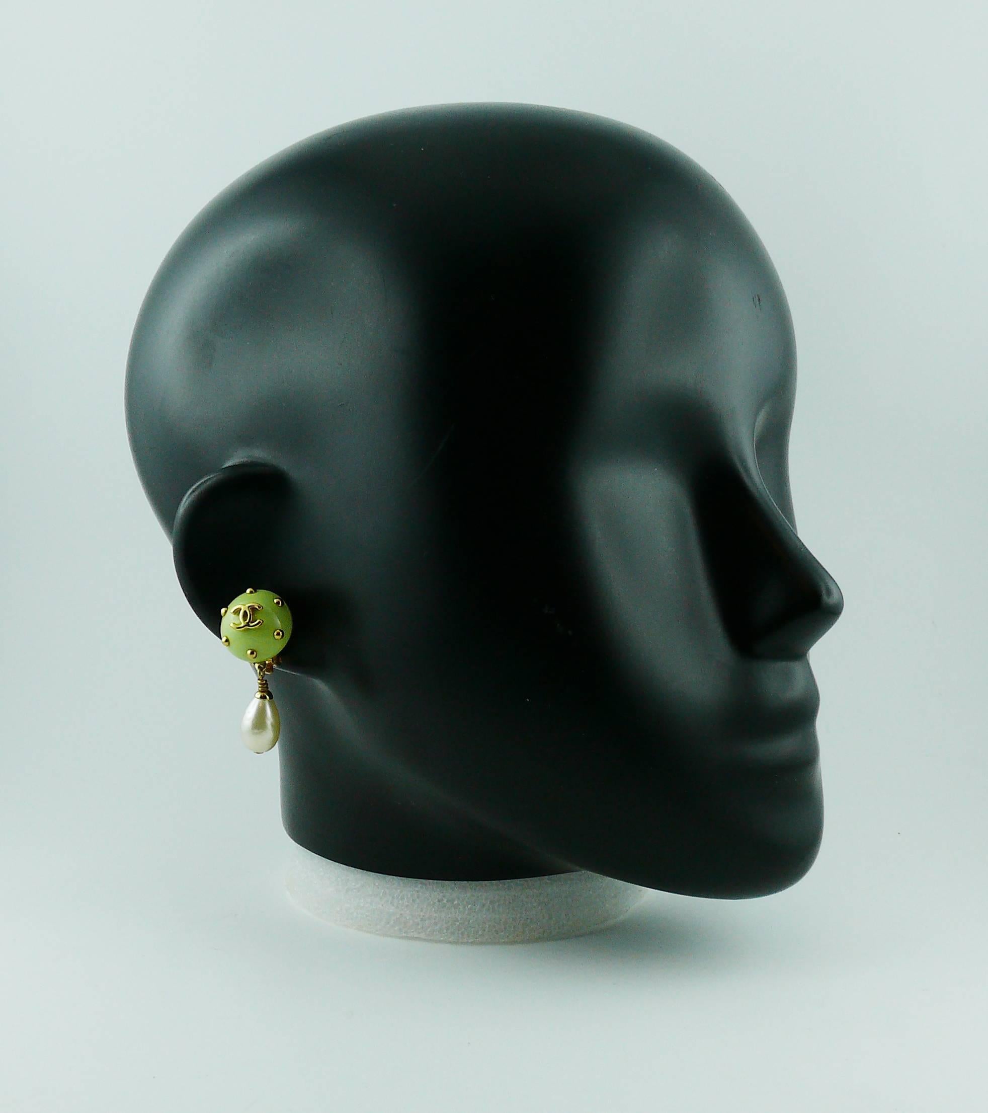 CHANEL vintage dangling earrings (clip-on) featuring a green resin studded dome top with CC logo at center and a faux pearl drop.

Cruise 1996 Collection.

Marked CHANEL 96 C Made in France.

Indicative measurements : height approx. 3.6 cm (1.42