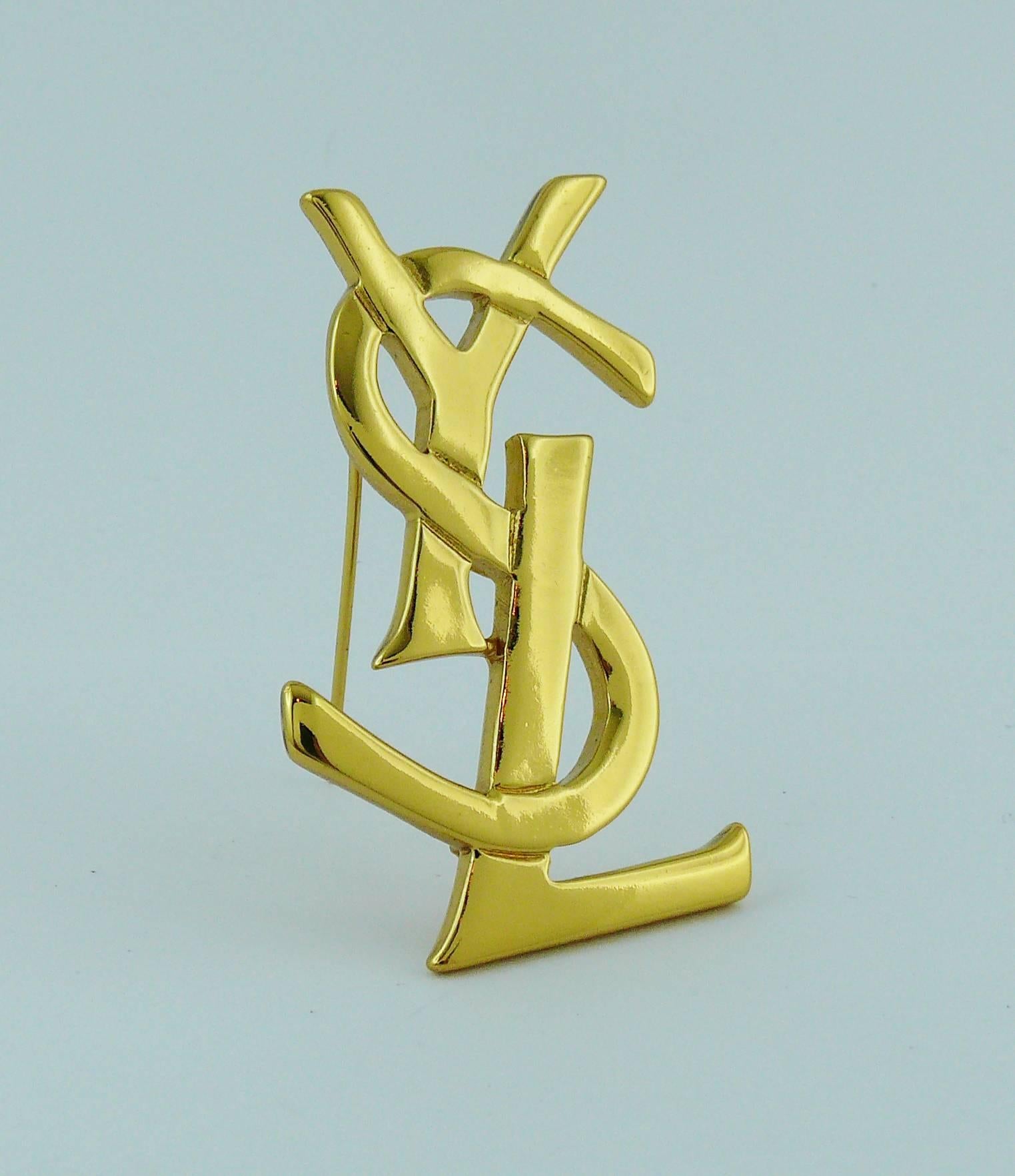 YVES SAINT LAURENT gold toned logo brooch.

Embossed Made in France.
Numbered E4.

Indicative measurements : max. height approx. 5.2 cm (2.05 inches) / max. width approx. 3.2 cm (1.26 inches).

JEWELRY CONDITION CHART
- New or never worn : item is